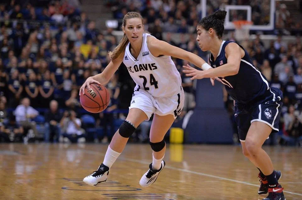 Brianna Salvatore Dueck, playing for UC Davis, looks drive past UConn’s Kia Nurse in 2014 (Photo credit: Aggie Sports)