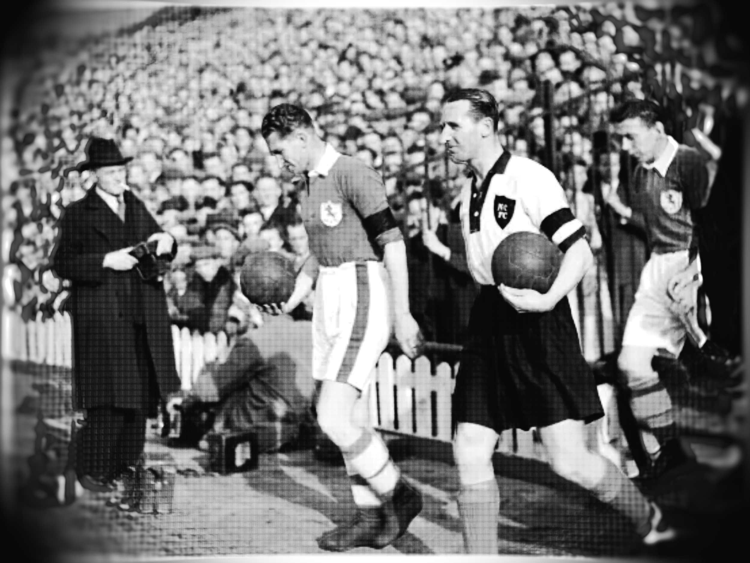 Black and white photo of a vintage soccer match with players on the field.