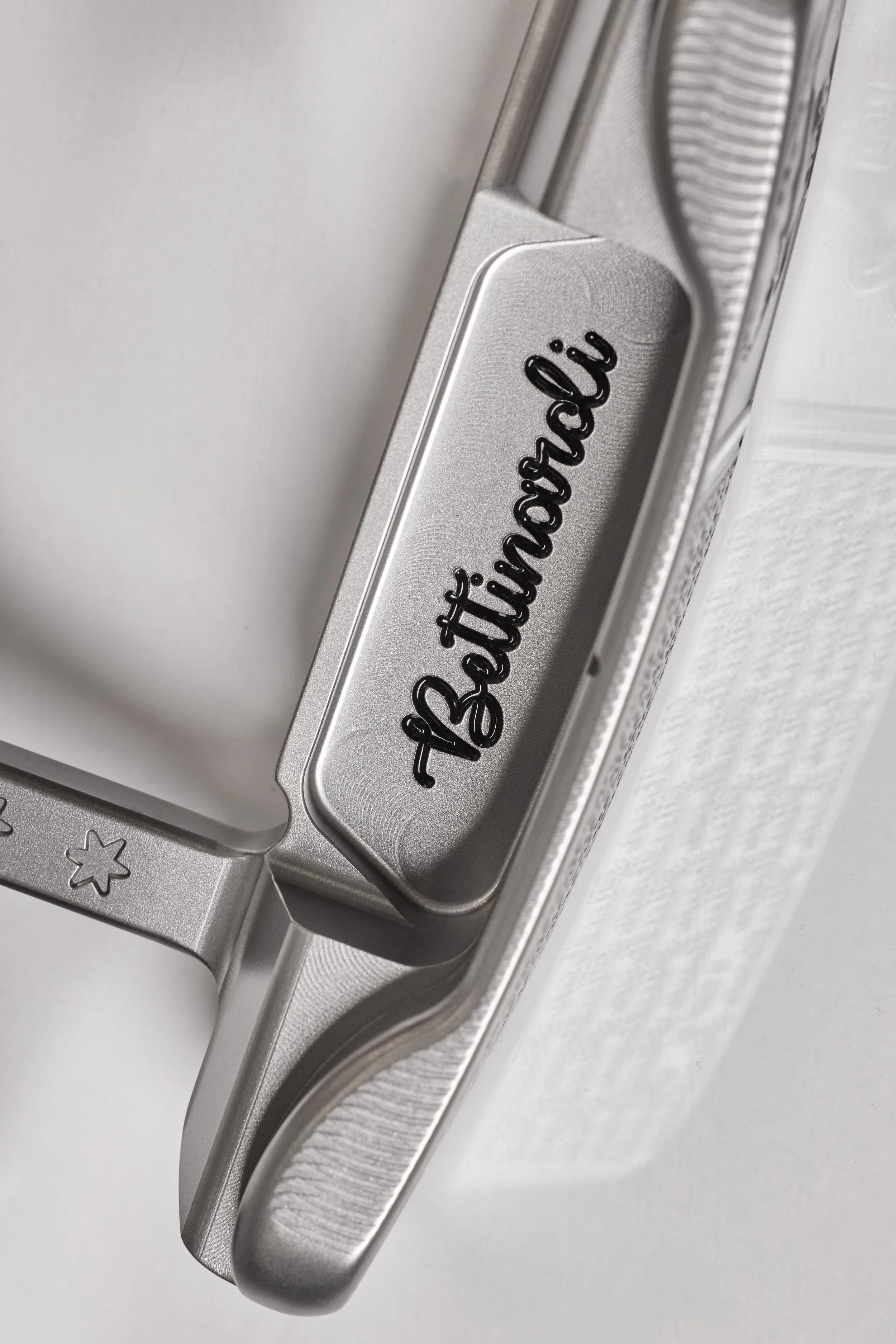 Close-up of a silver metallic lighter with the words 'stay humble' engraved in black cursive on its surface.