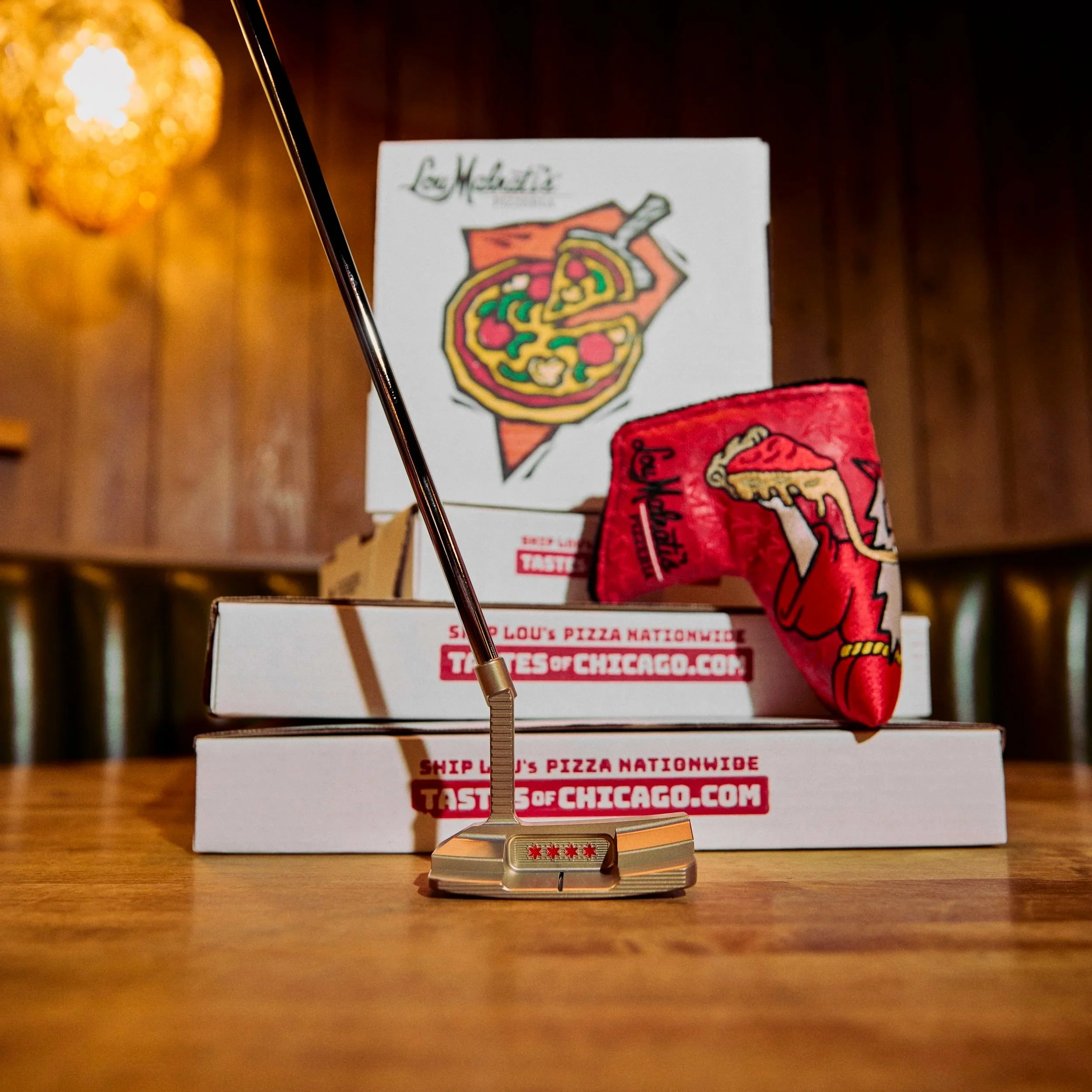 A close-up of a Chicago-themed chess piece on a wooden surface with a pizza box in the background.
