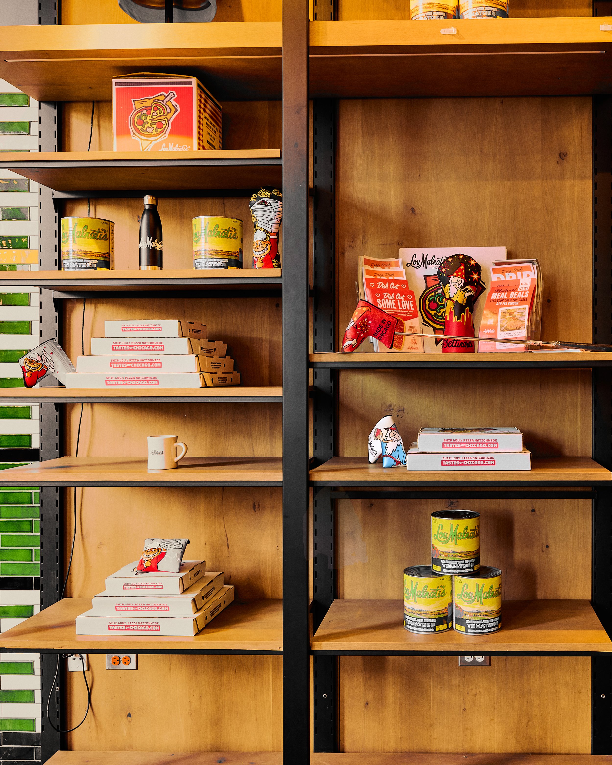 Empty wooden shelves with Lisa's tomato cans, pizza boxes, and some branded merchandise. The shelves are mostly vacant with few products left.