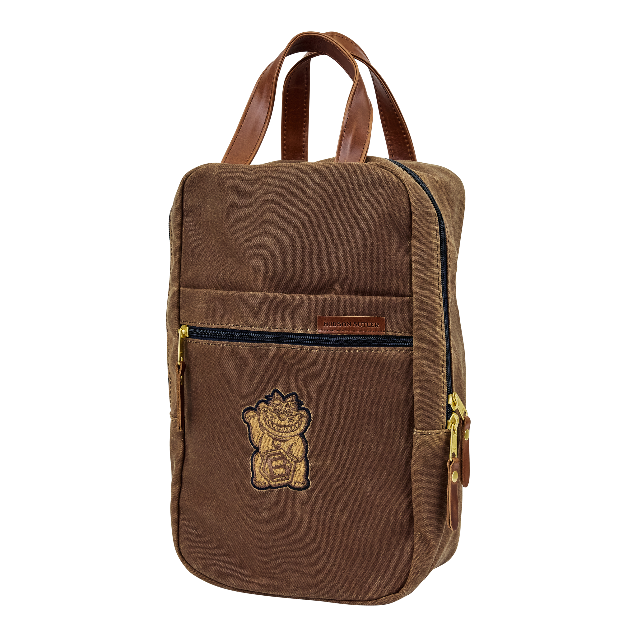 Brown backpack with a lion logo embroidered on the front pocket, leather straps, and gold zippers.