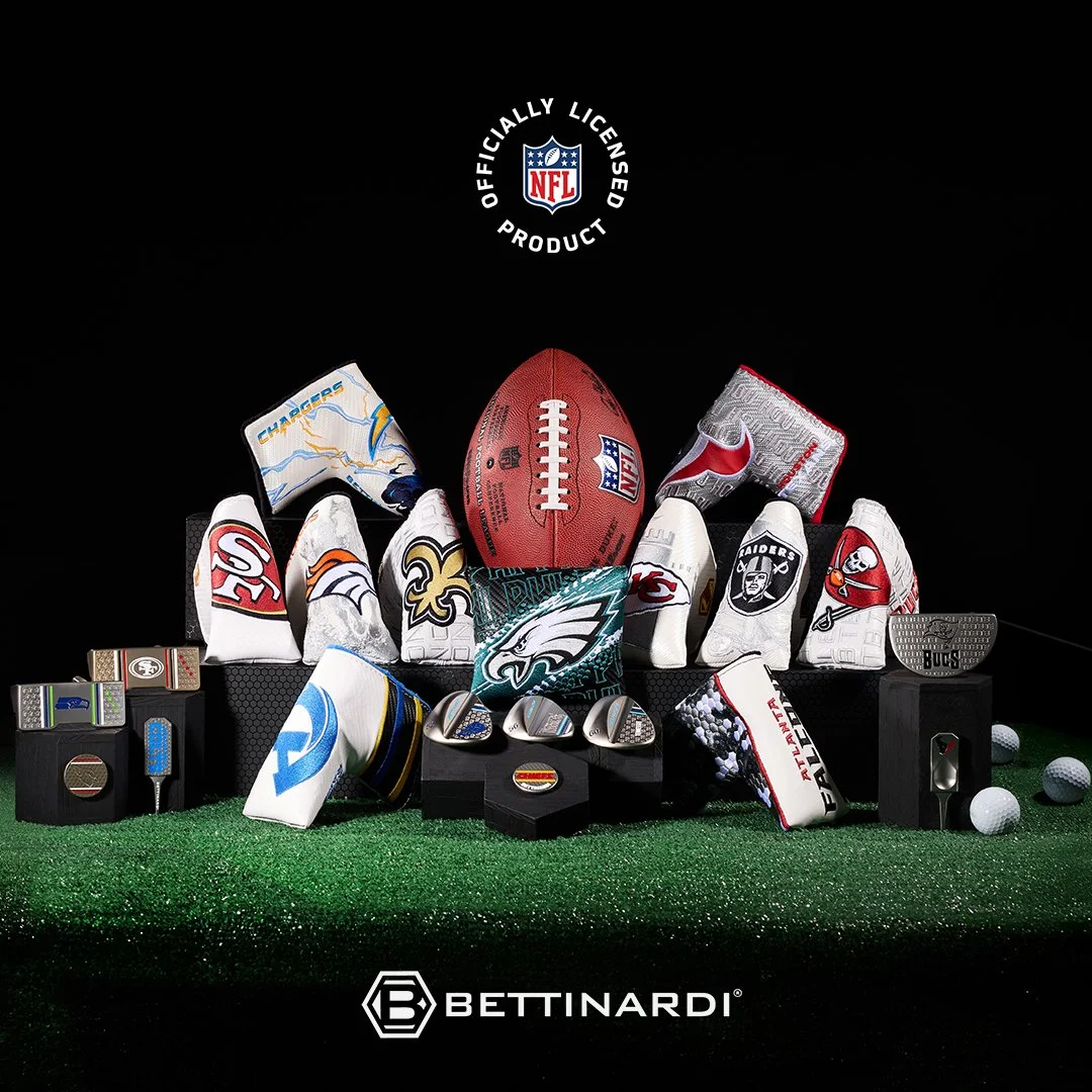 Display of NFL merchandise including footballs, gloves with team logos, and golf accessories on a green surface against a black background, with a Betinardi logo at the bottom.