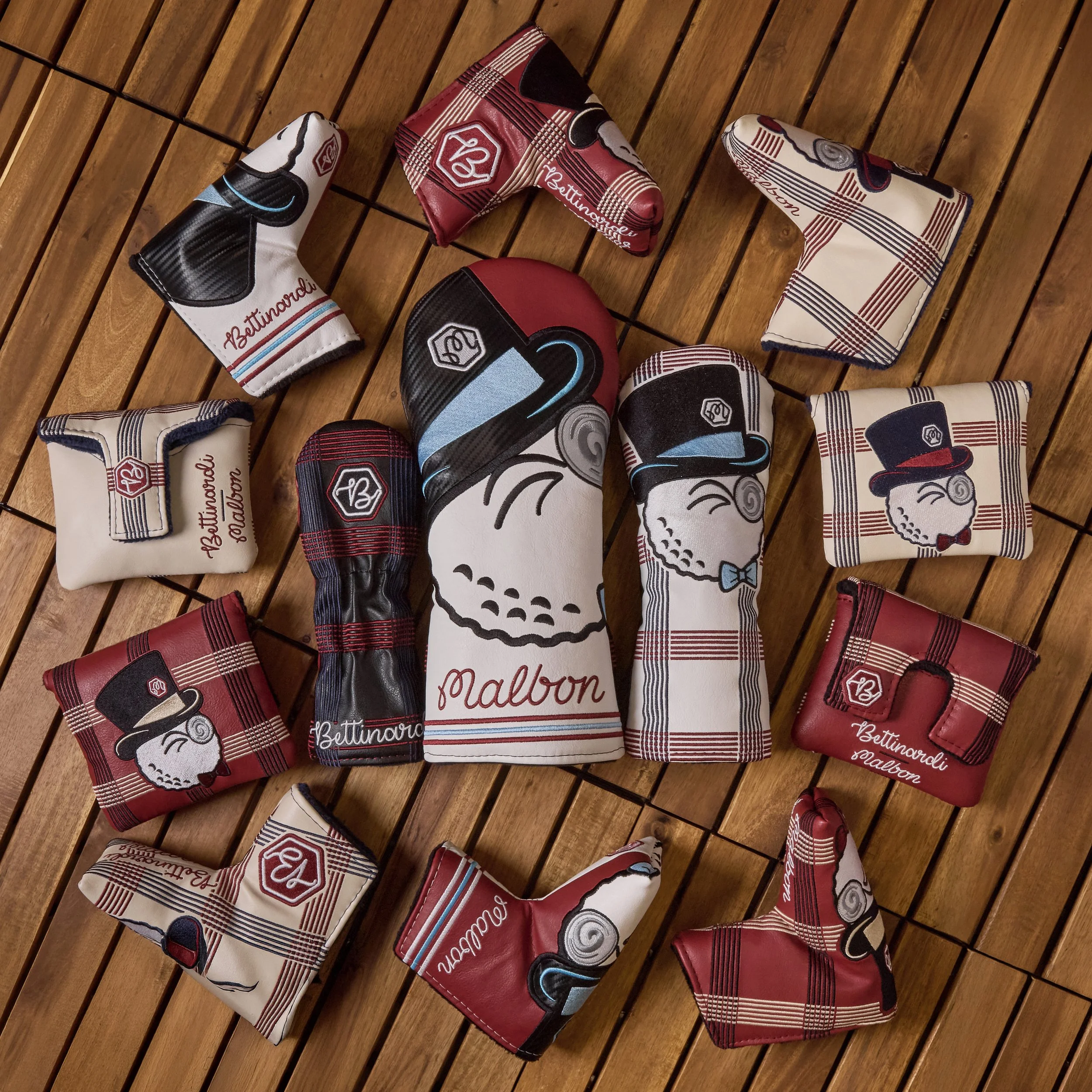 A collection of golf club headcovers with various patterns and colors, laid out on a wooden surface.