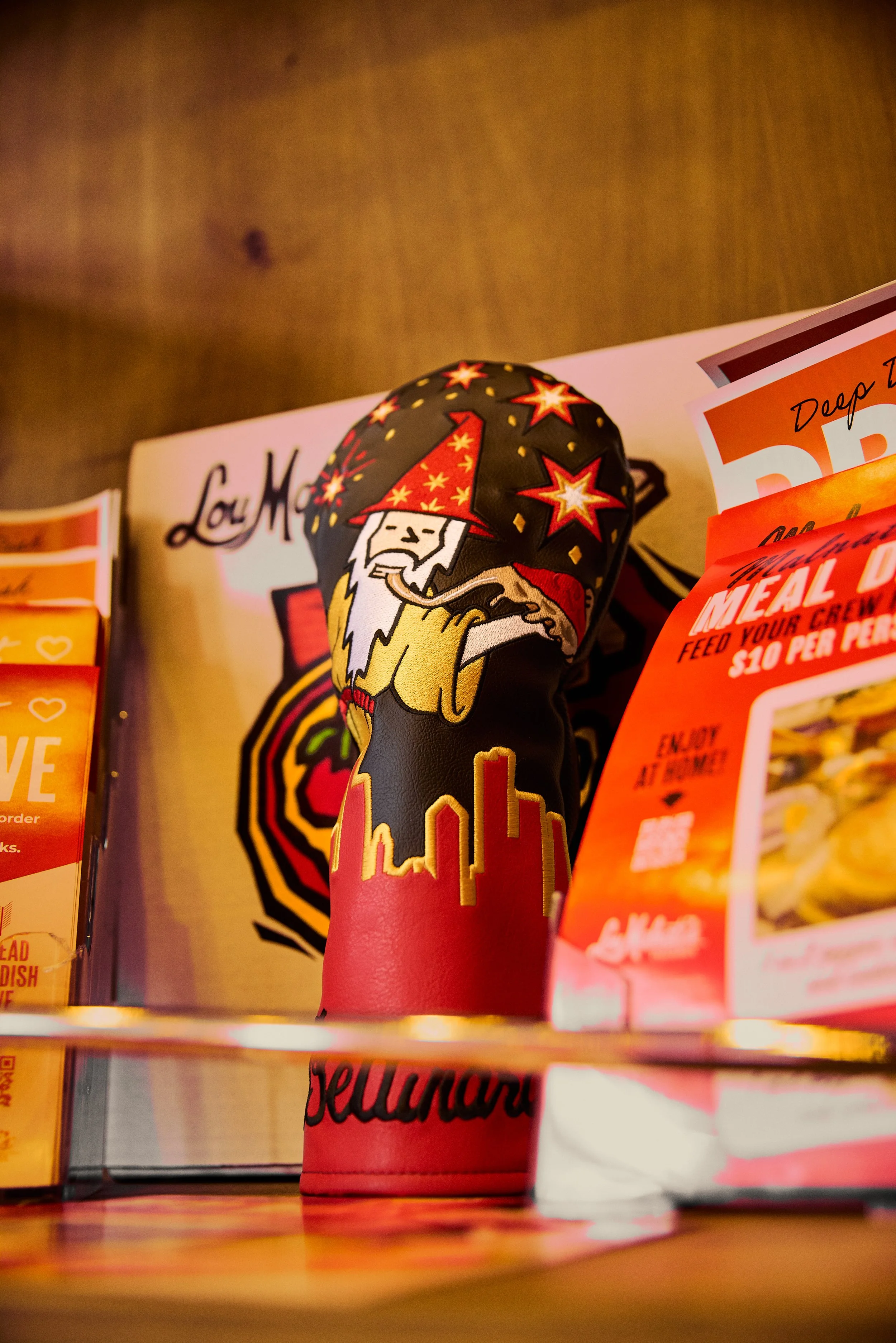 A vending machine with a colorful capsule toy in the shape of a wizard with a red wizard hat surrounded by stars, partially obscuring a sign and flyers on the vending machine.