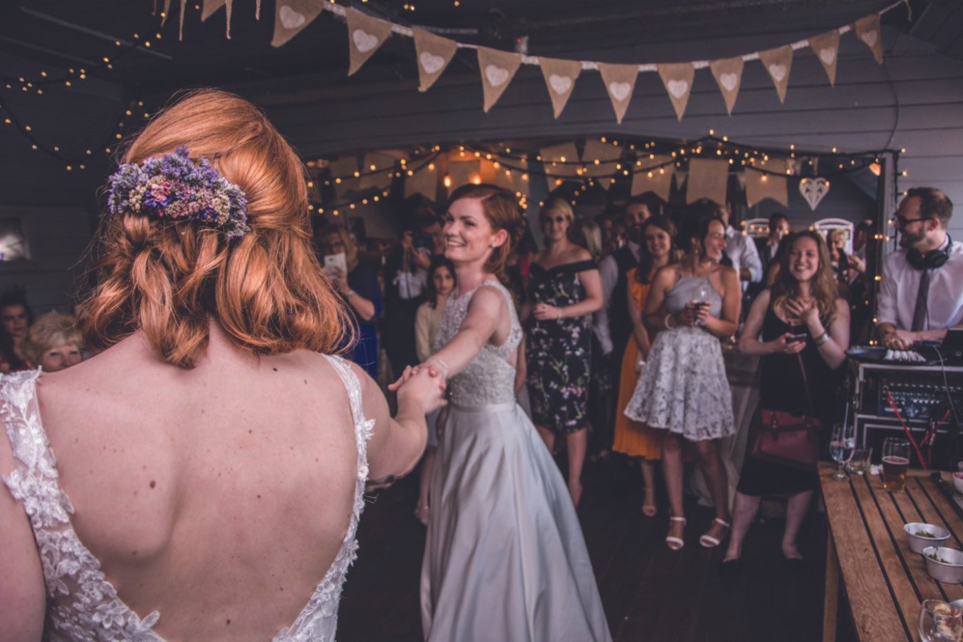 A bride and groom dancing at a wedding reception inside the Hold Bar with guests watching and smiling in a decorated indoor venue.