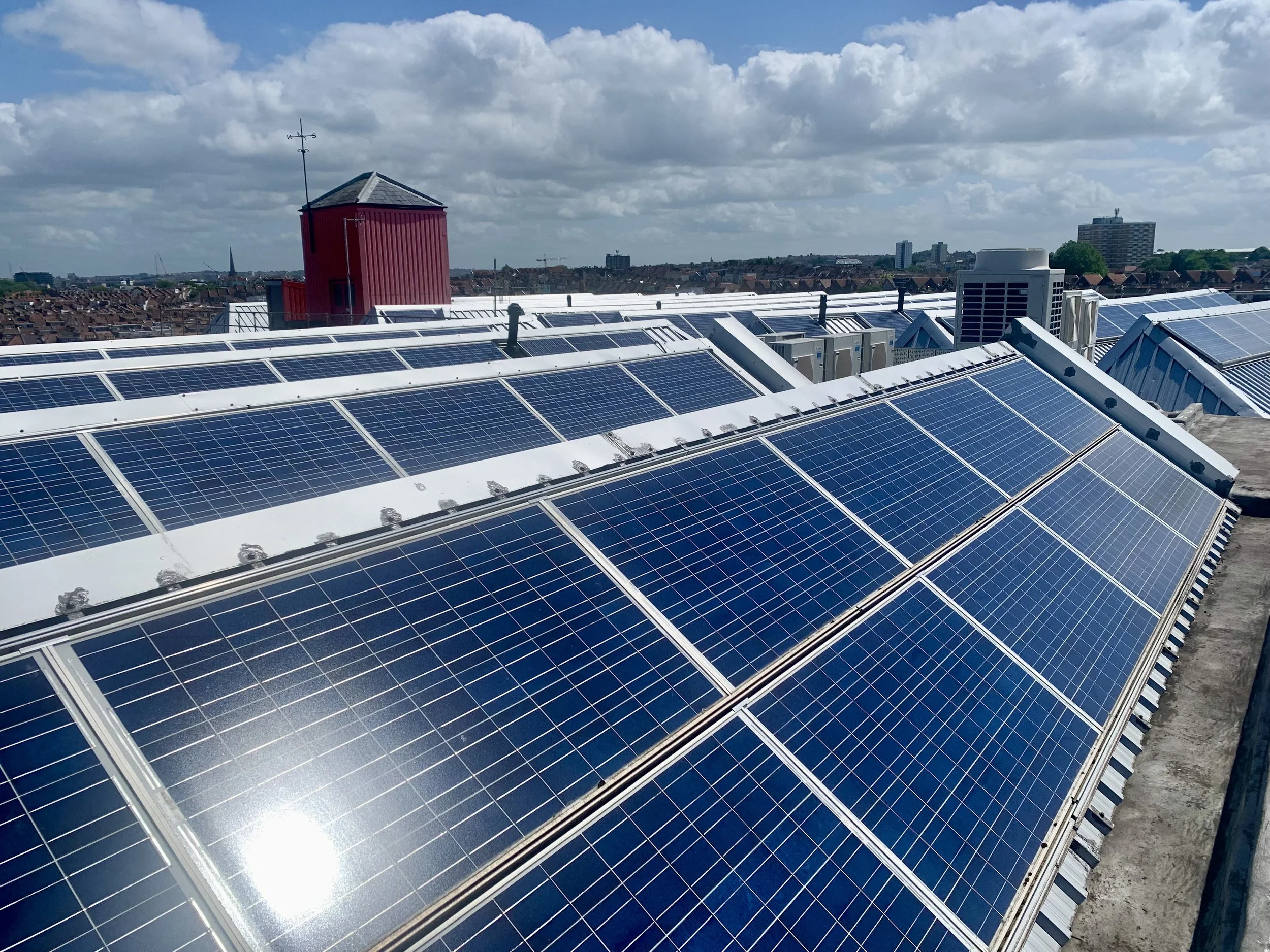 Rooftop with photovoltaic tiles and a small red Tobacco Factory building, powering 33 percent of Tobacco Factory Theatre's electricity.