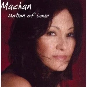Close-up portrait of Machan with a gentle smile against a dark red background, promoting the song 'Motion of Love'.