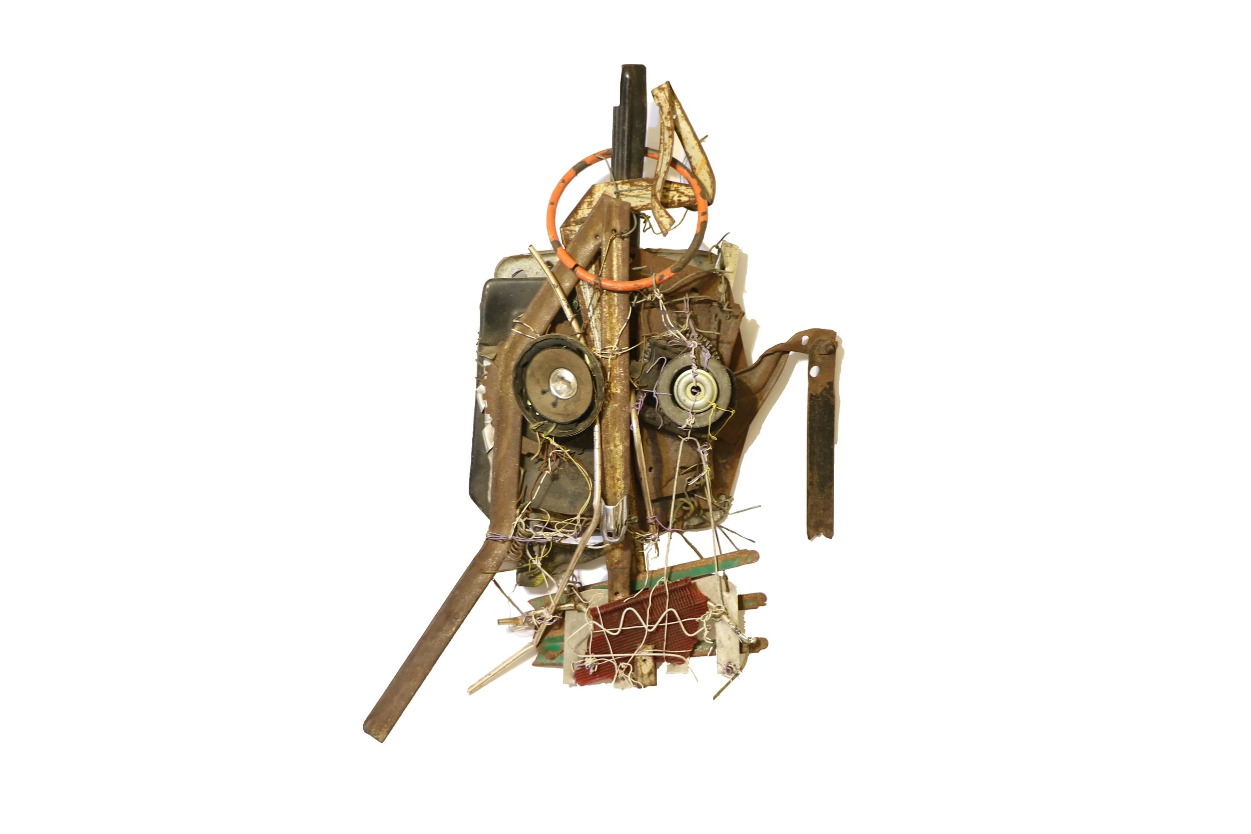Found object sculpture by Karl A. McIntosh featuring salvaged metal parts, gears, wires, and mechanical components arranged in an abstract human-like form.
