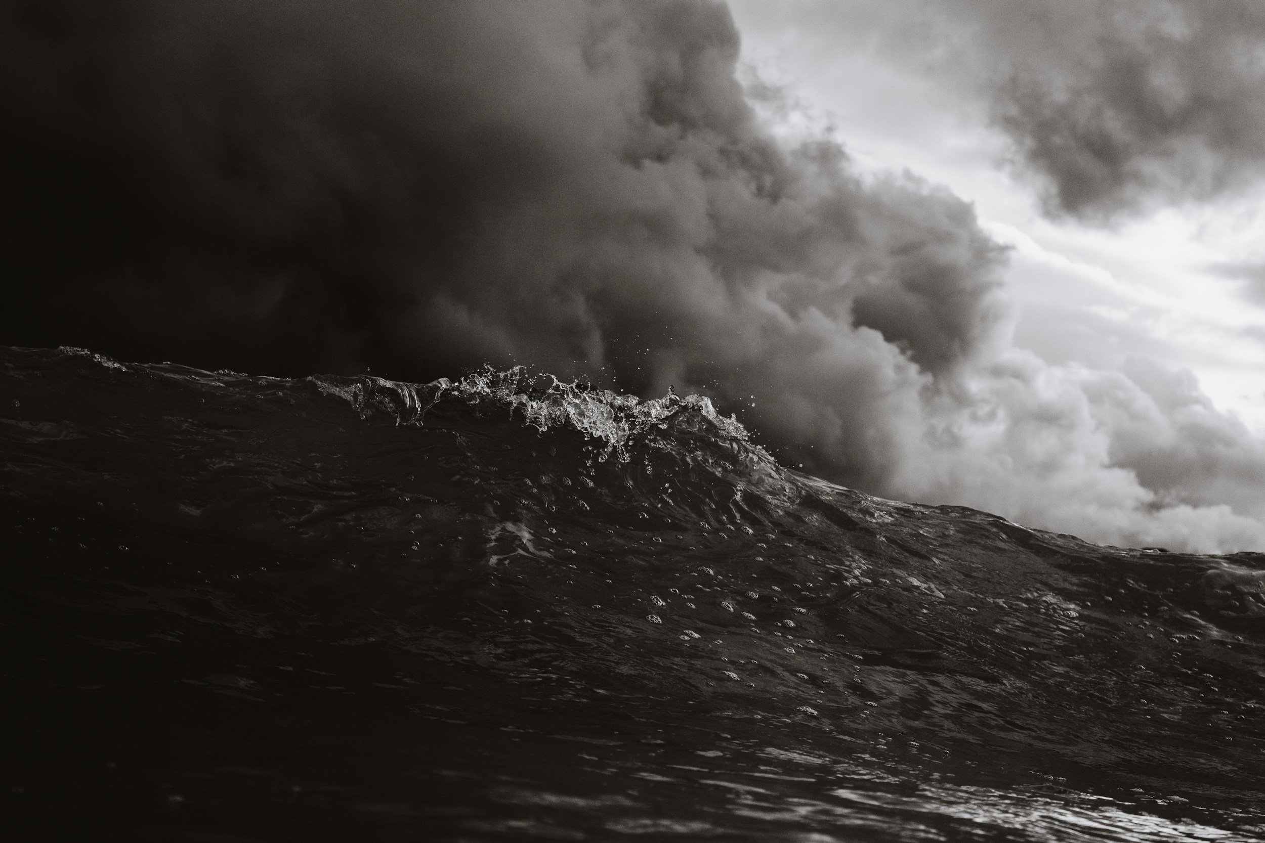 Dark storm cloud over a turbulent ocean with large waves.