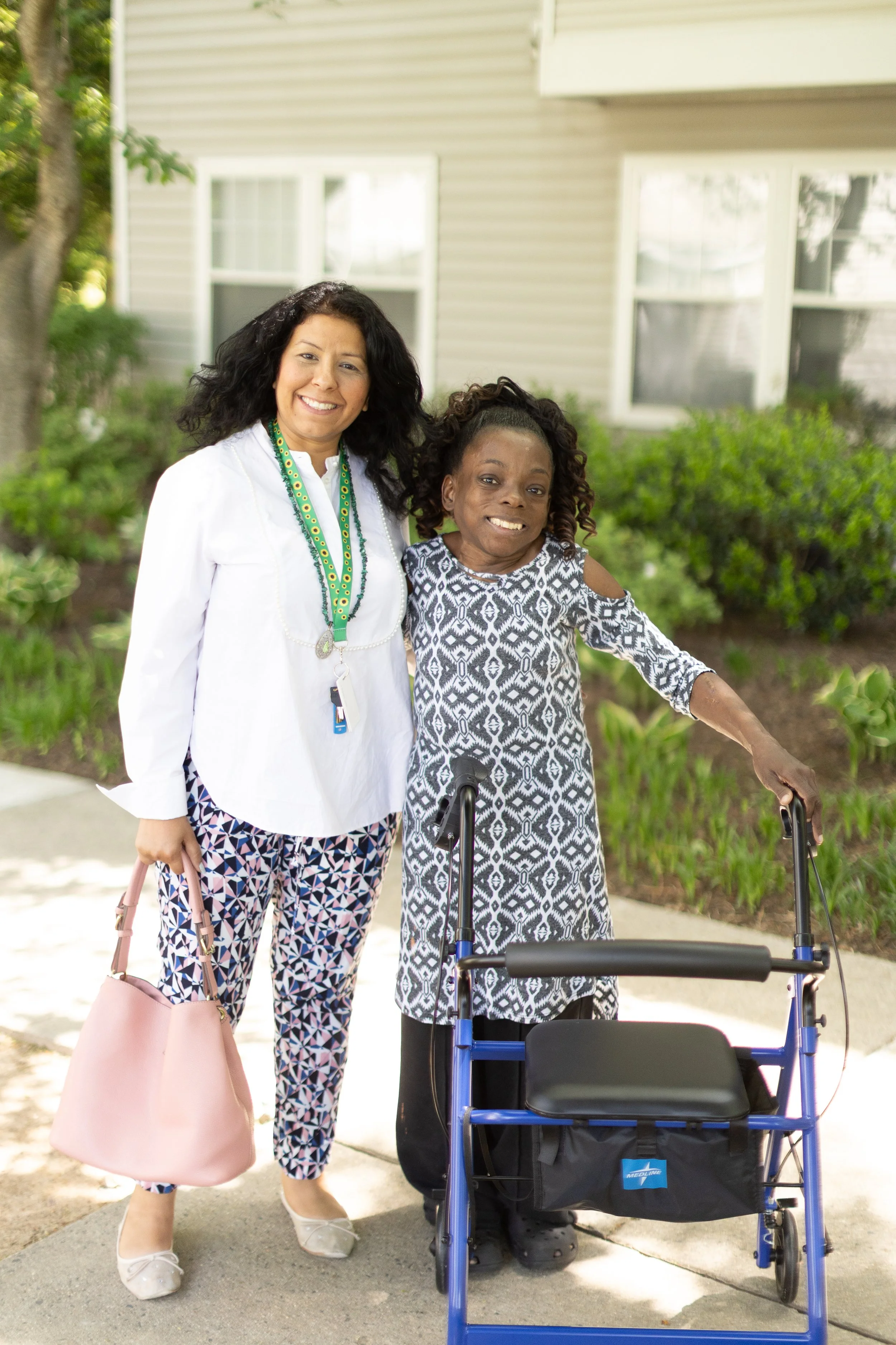 Cornerstones' Community Case Manager and program participant, who is disabled and using a walker, both smiling at the camera.