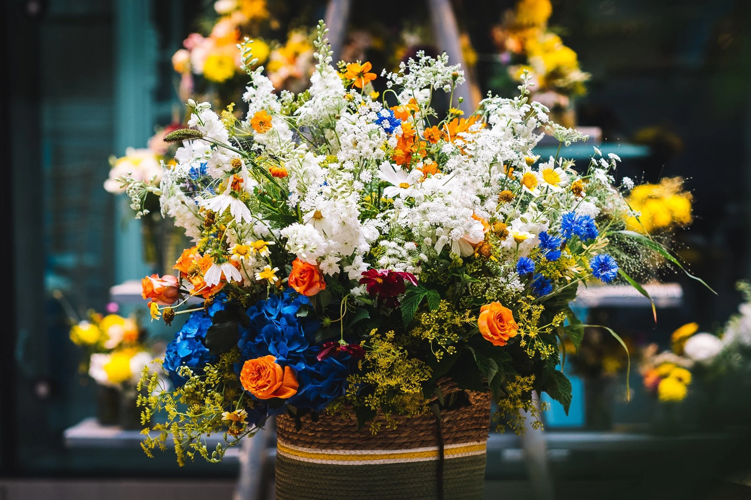 Composition florale de fleurs colorées dans un panier en osier.