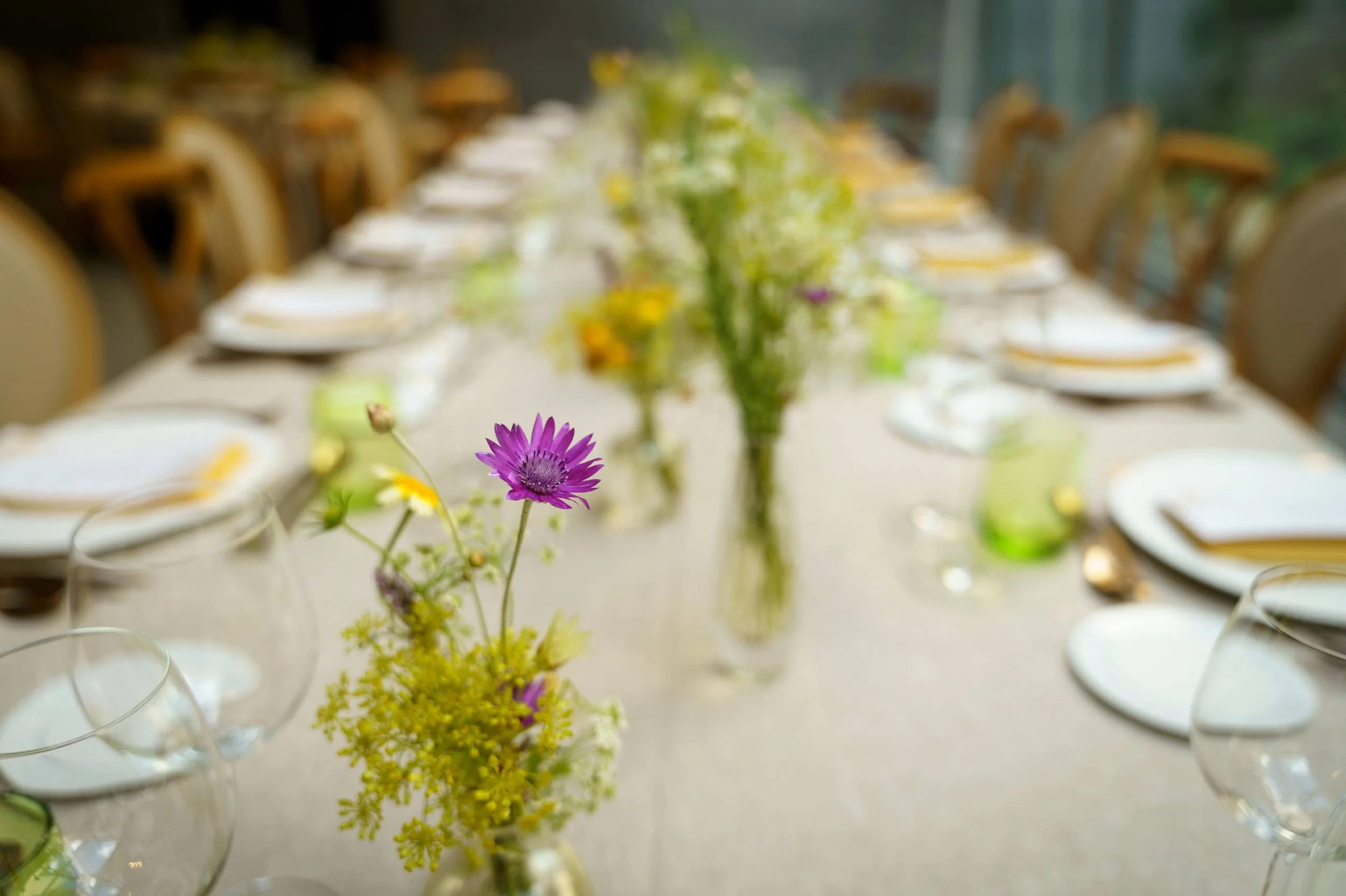 Table élégante décorée de fleurs colorées, serviettes et assiettes pour un événement formel.