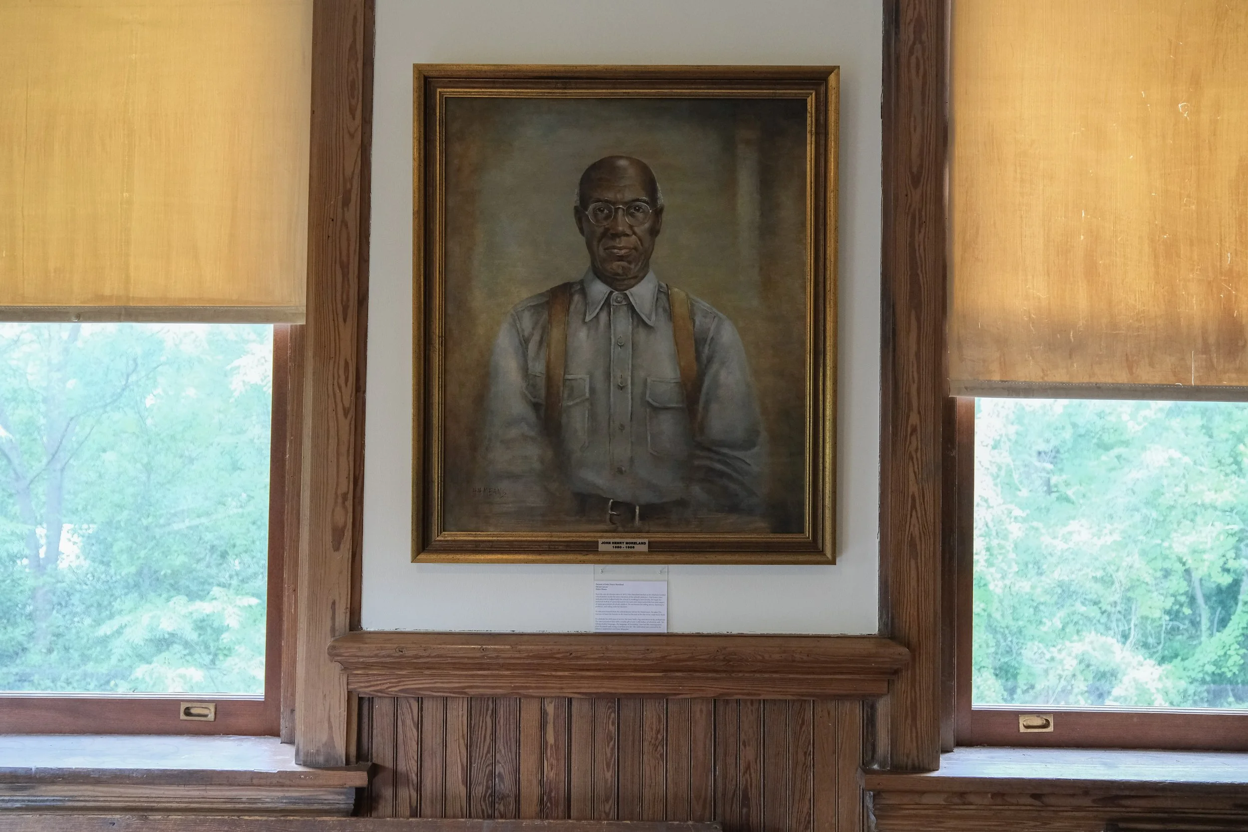 A framed portrait of John Henry Moreland, 1850-1900, hangs on the wall.