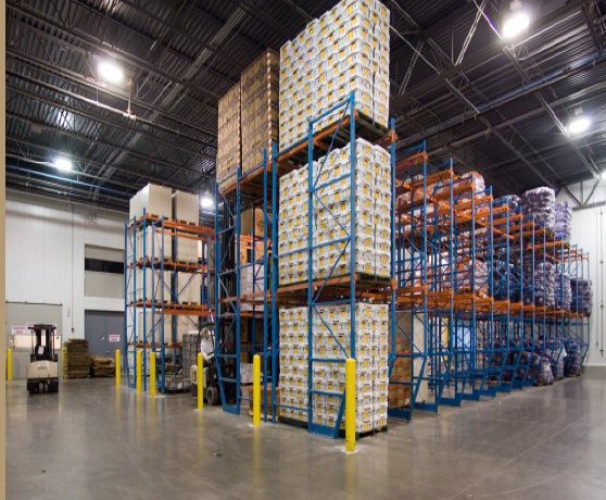 Shelving units filled with large quantities of boxed and wrapped goods in a warehouse.