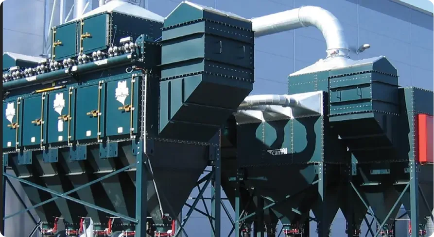 Industrial large-scale dust collection or filtration system with multiple interconnected units and ductwork.