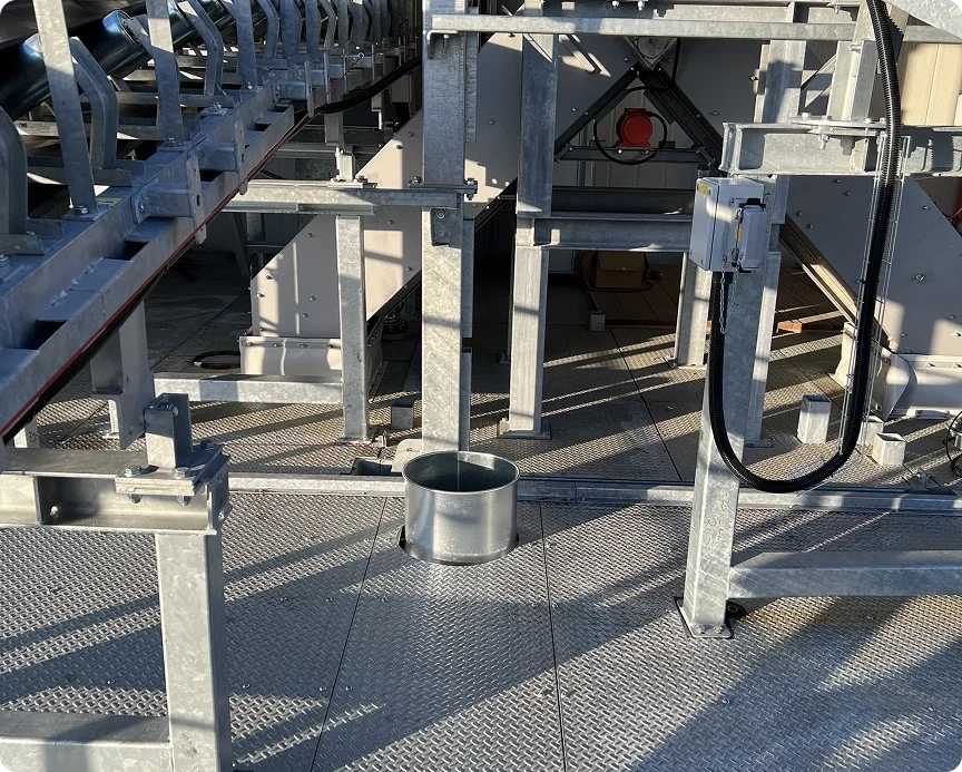 Metal scaffolding and structures on a diamond plate floor with shadows, electrical boxes, wiring, and a cylindrical container.