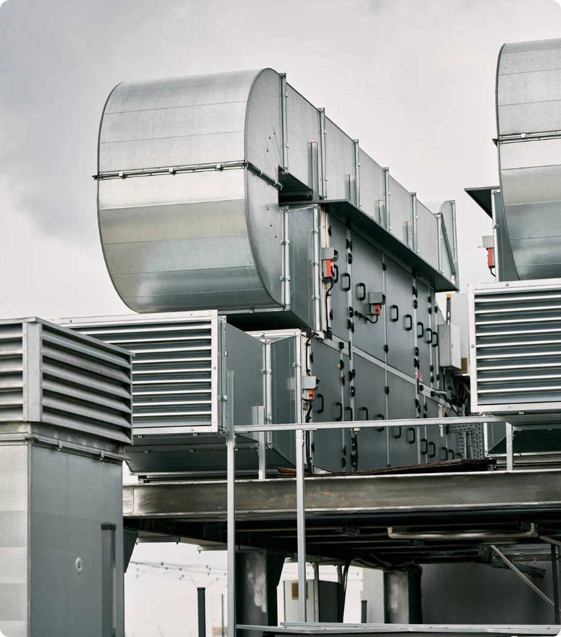 Industrial HVAC system with large metal air ducts and vents on building rooftop.