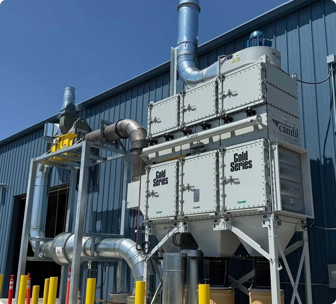 Industrial HVAC or air filtration system mounted on the exterior of a blue building with ducts and vents.