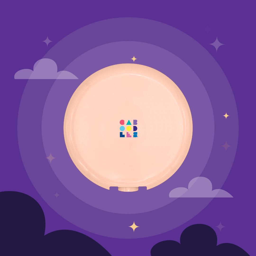 A pink circular object with colorful blocks arranged in a pattern in the center, set against a purple background with stars and clouds.
