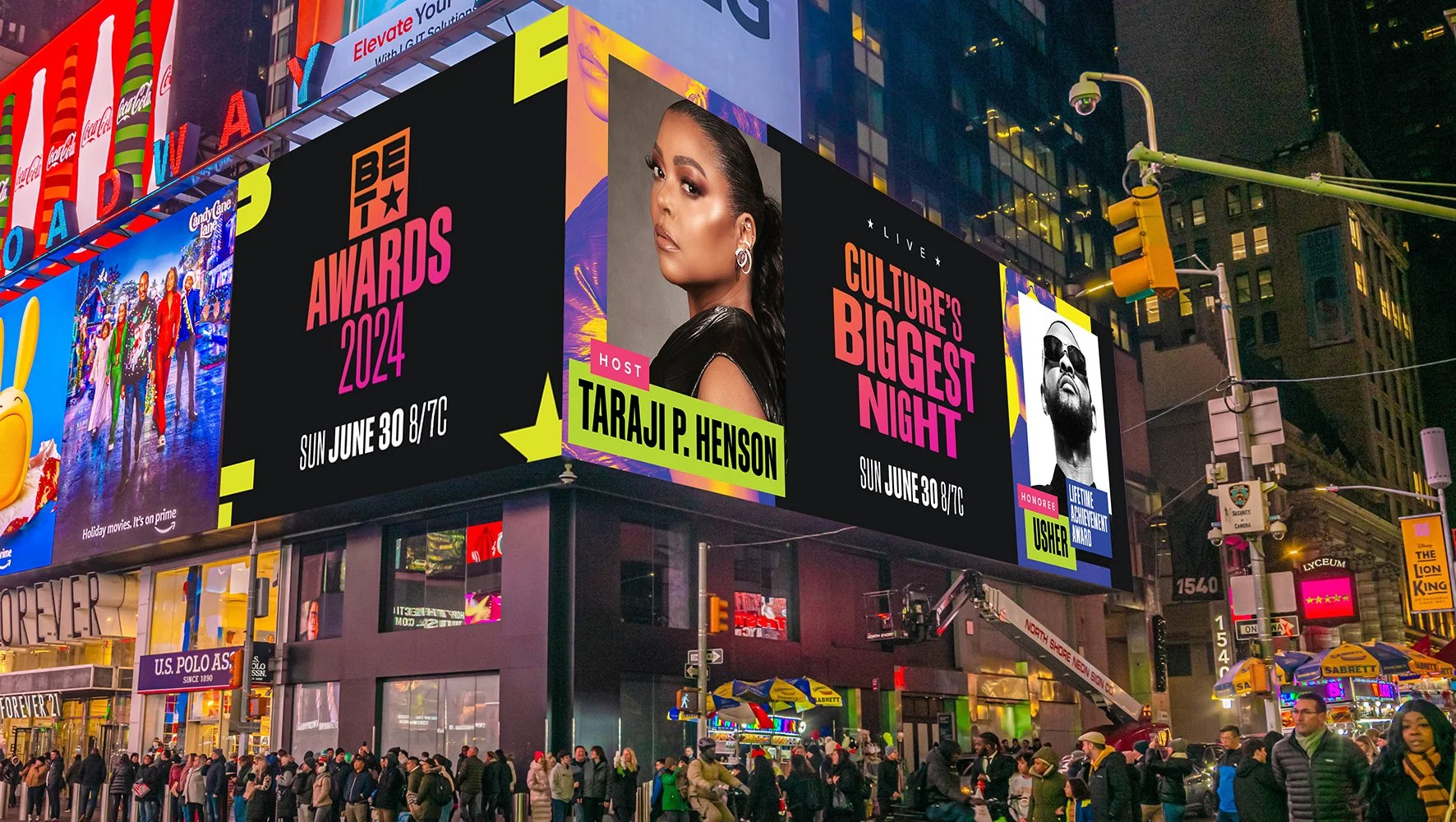 A digital billboard in Times Square advertising the BET Awards 2024, hosted by Taraji P. Henson, with images of two celebrities on the screen and a crowd of people below.
