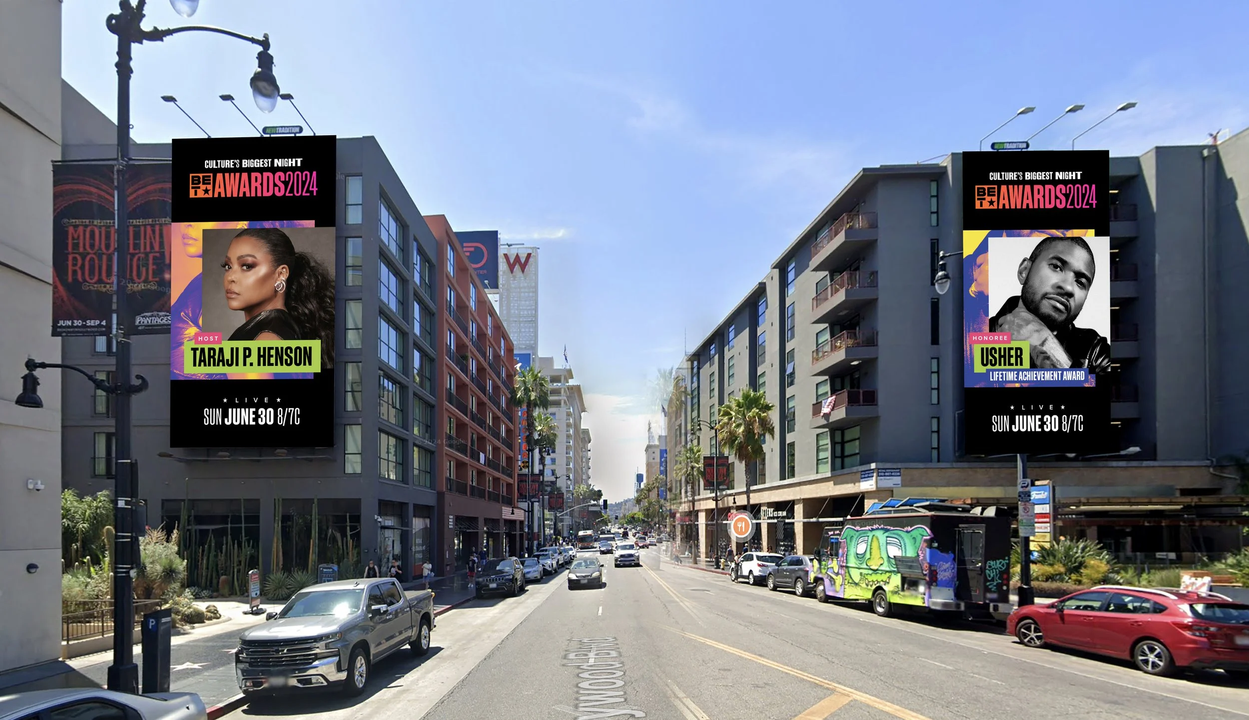 City street with tall buildings, digital billboards on each side, parked cars, and pedestrians; blue sky overhead.