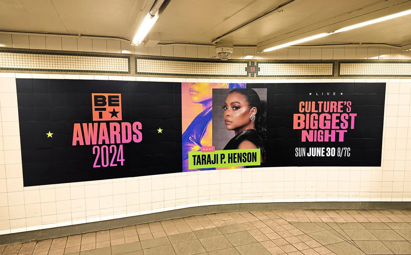 Advertisement poster for the 2024 BET Awards with host Taraji P. Henson, announcing the event on Sunday, June 30 at 8/7c, displayed in an underground subway station.