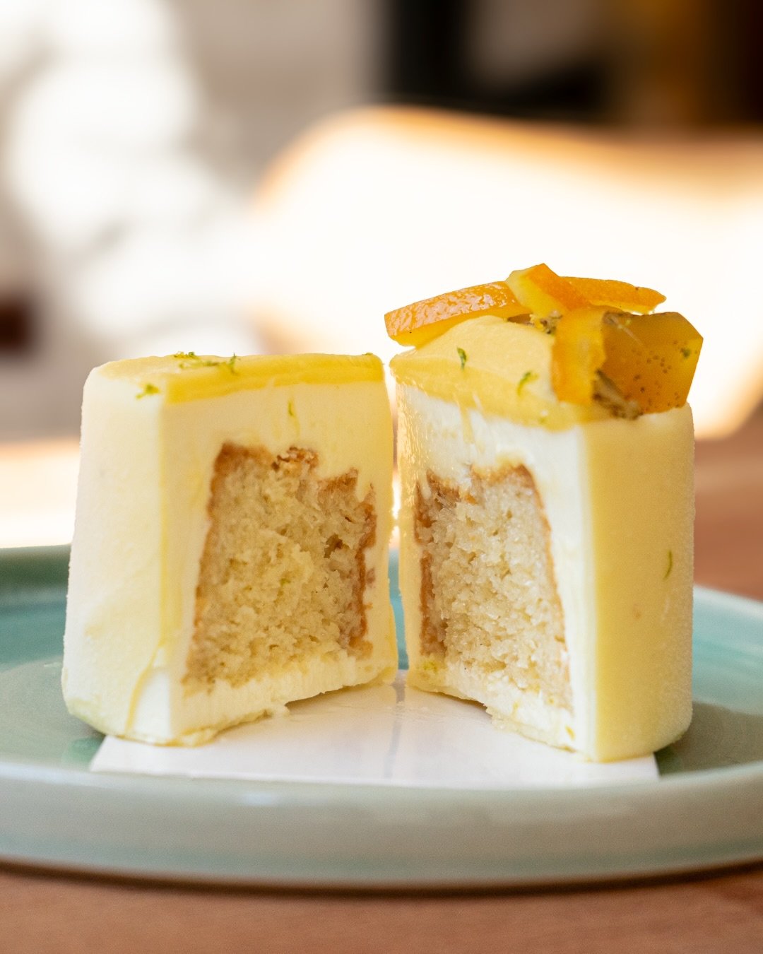 Gâteau de chez Xocolatte à Lille, en forme de cube avec une garniture à la mangue et des tranches de fruits exotiques sur le dessus, coupé en deux pour révéler la texture intérieure, 