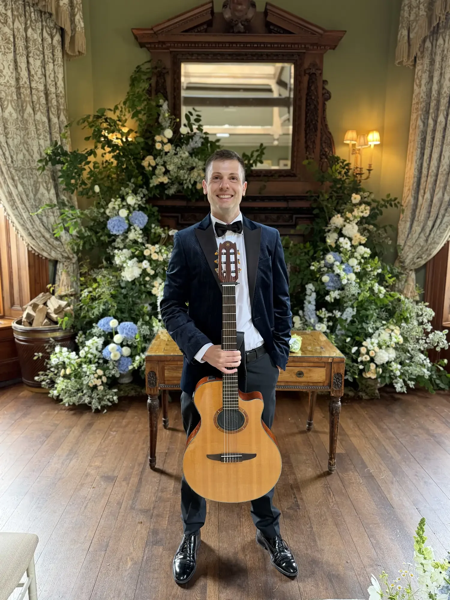 wedding-guitarist-floral-backdrop-castle-leslie.webp