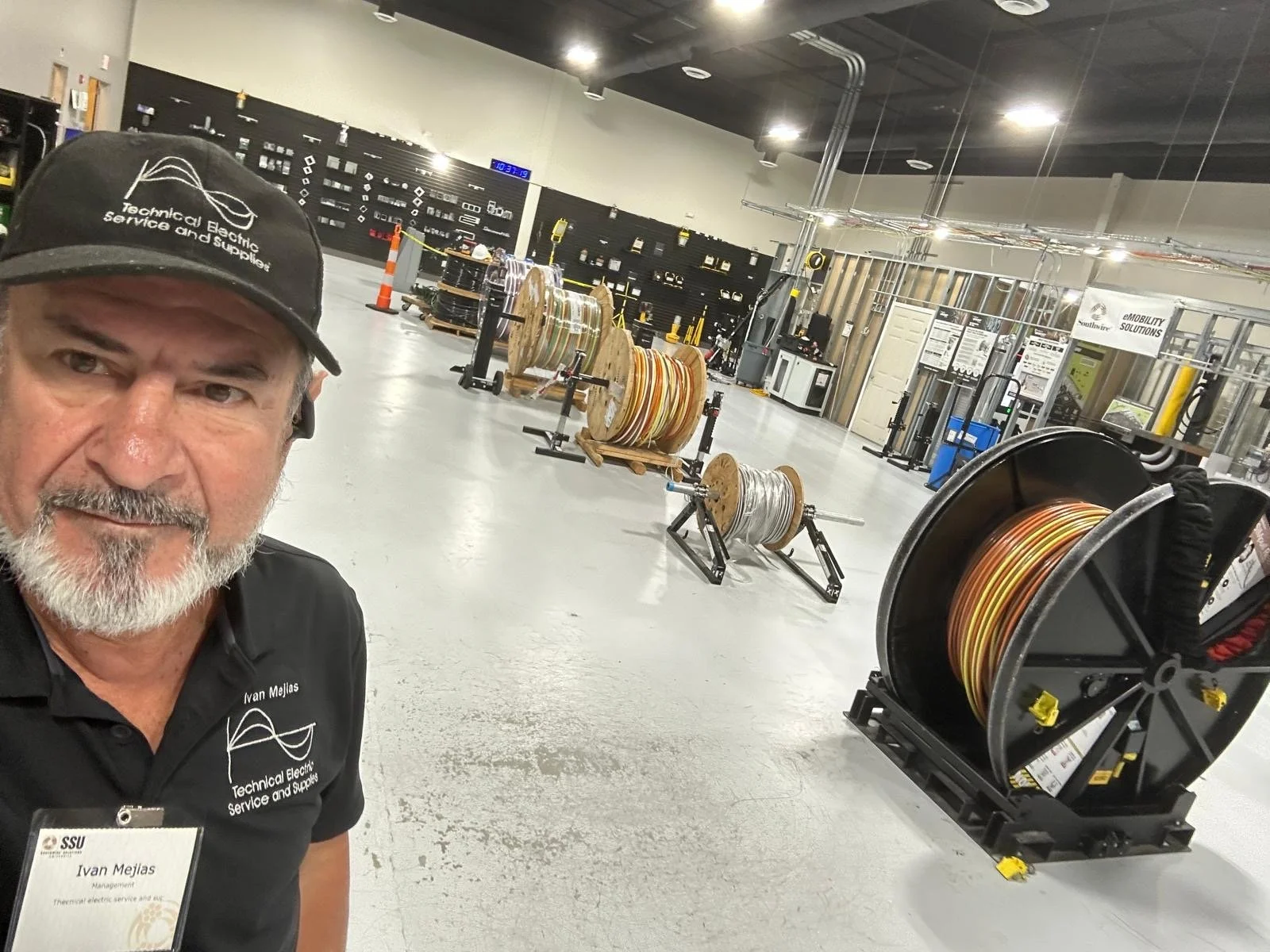 Technical Electric Service and Supplies with industrial spools of wire and electrical components being examined.