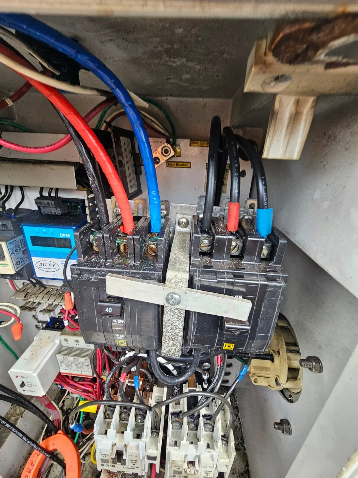 Electrical control panel with multiple wires, a digital meter, and circuit breakers.