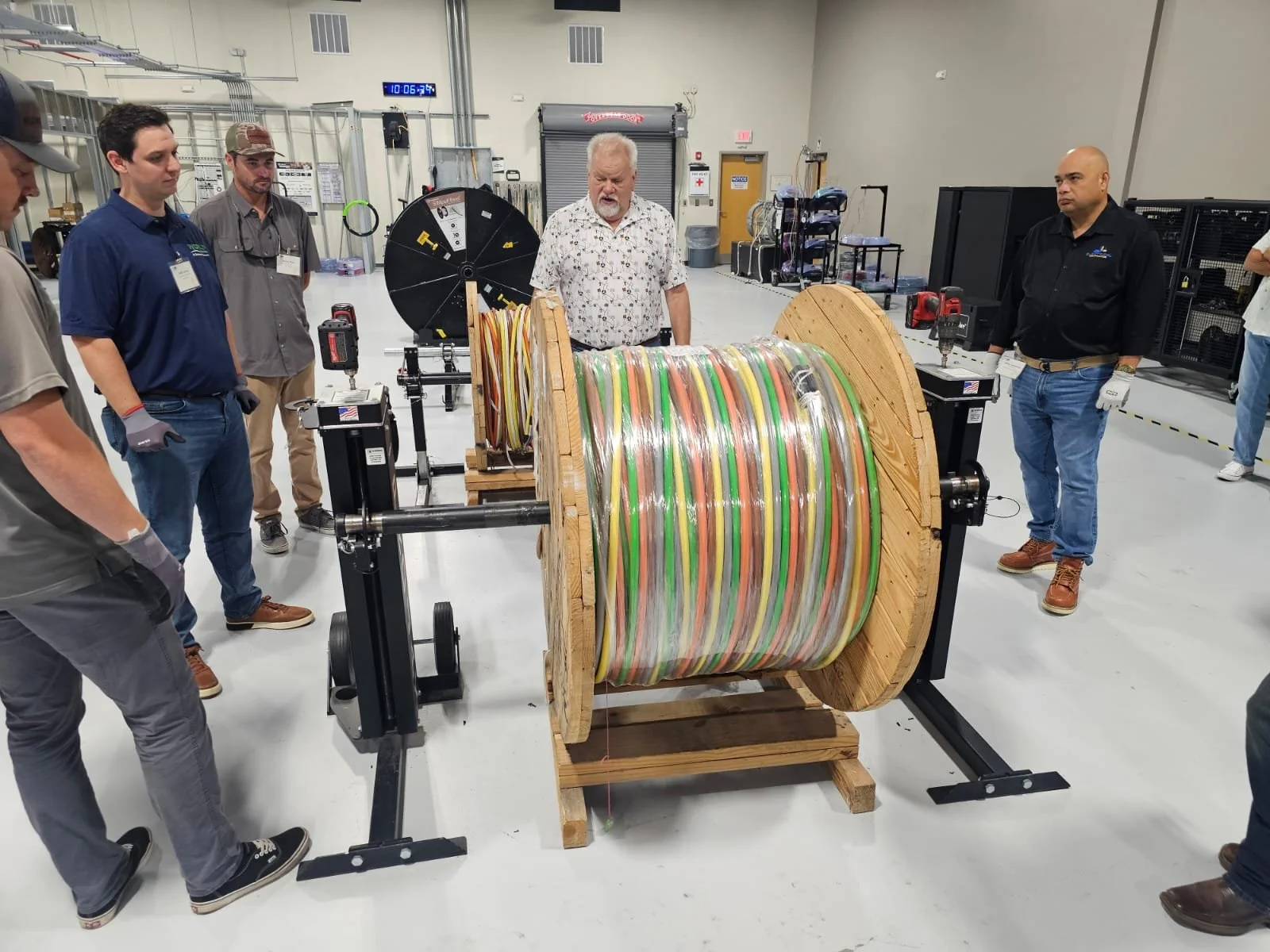 Large spool of multicolored electrical cable being examined.