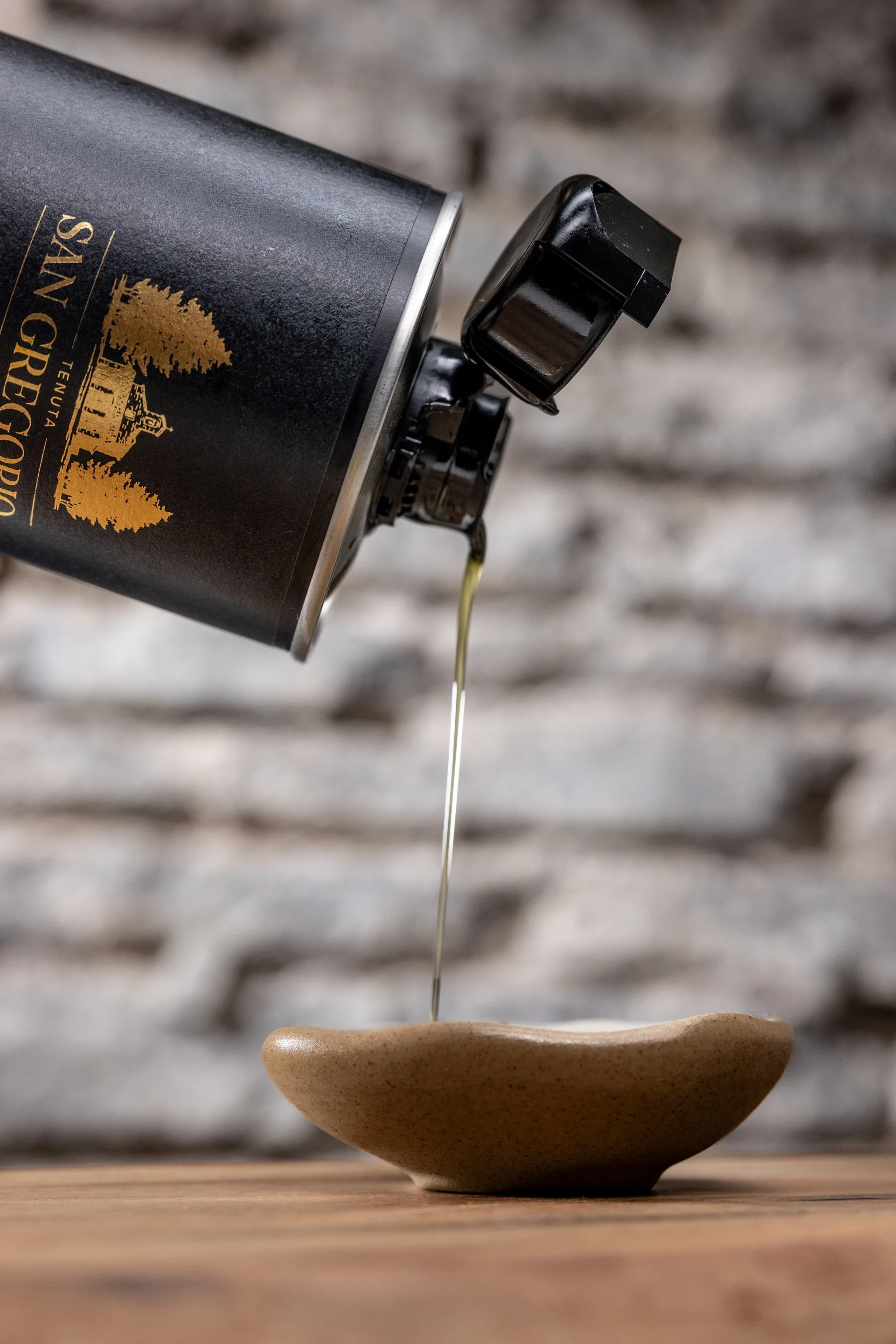 a bottle of San Gregorio olive oil pouring into a small dish