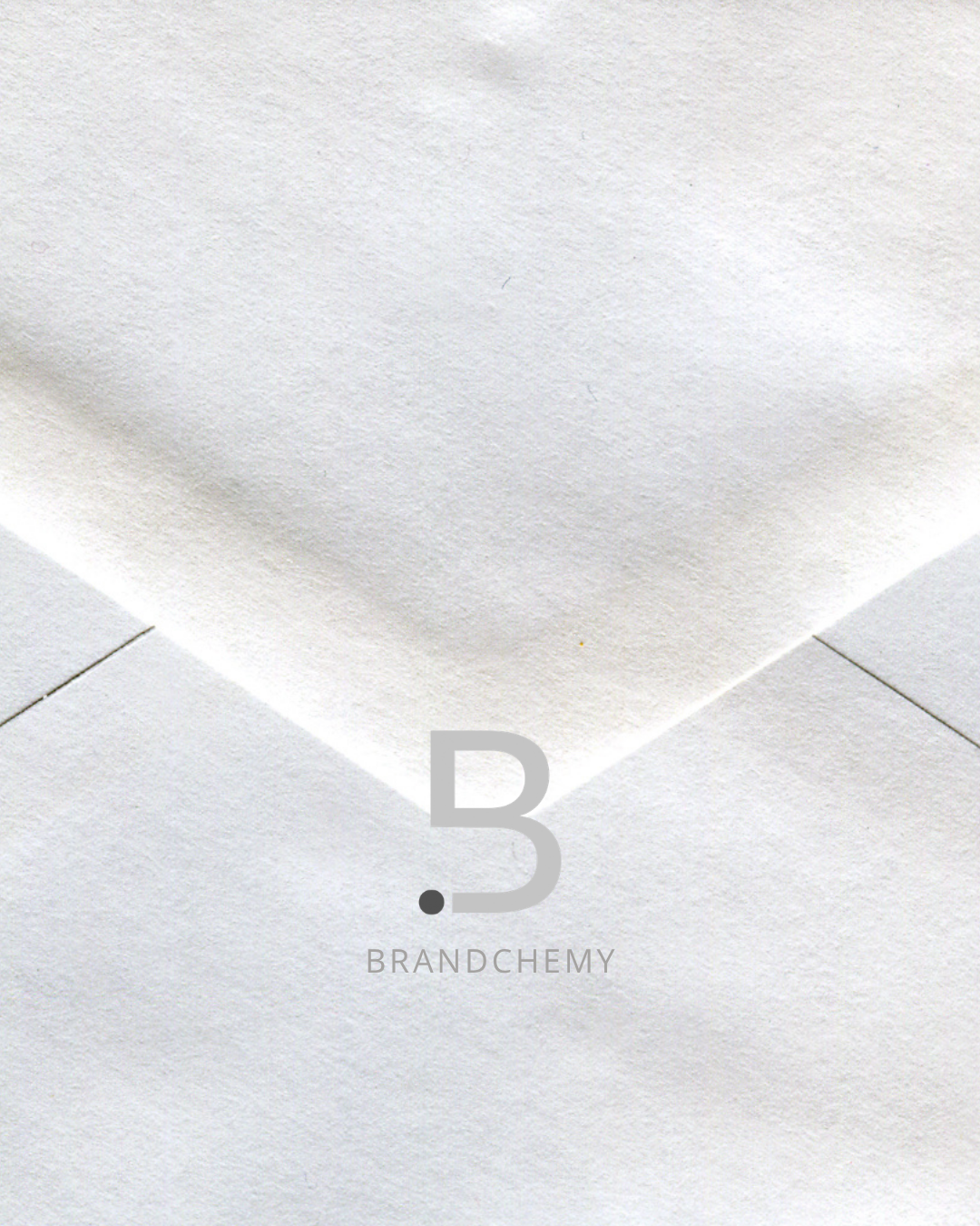 Close-up of a white paper with the logo 'B.3' and the text 'BRANDCHEMY' printed on it, situated on a tiled white surface.