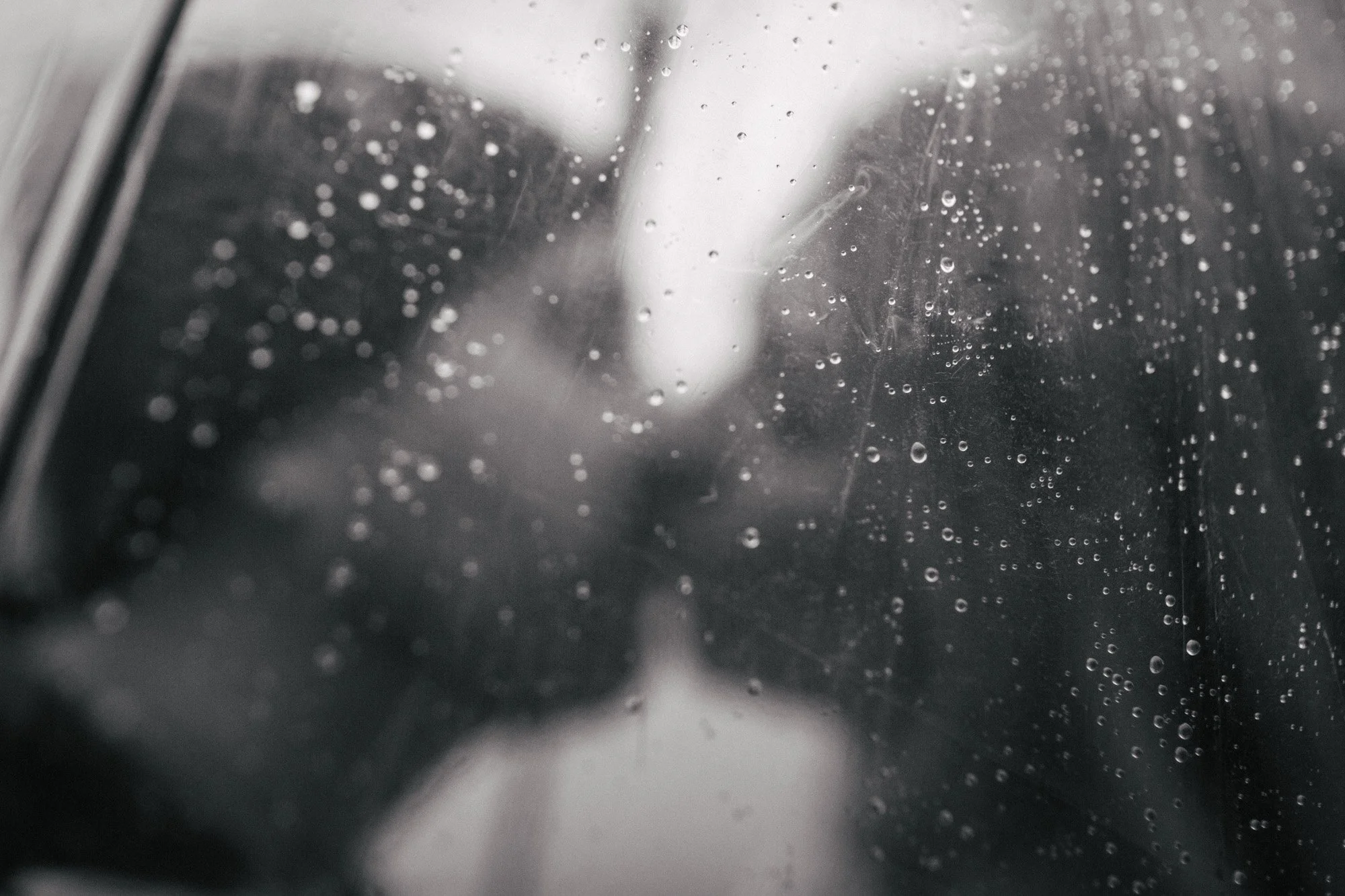 Close-up of a wet, foggy window with raindrops on the glass.