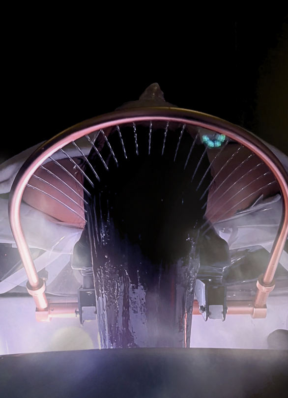 Close-up of a jet engine with water spray during testing or maintenance.