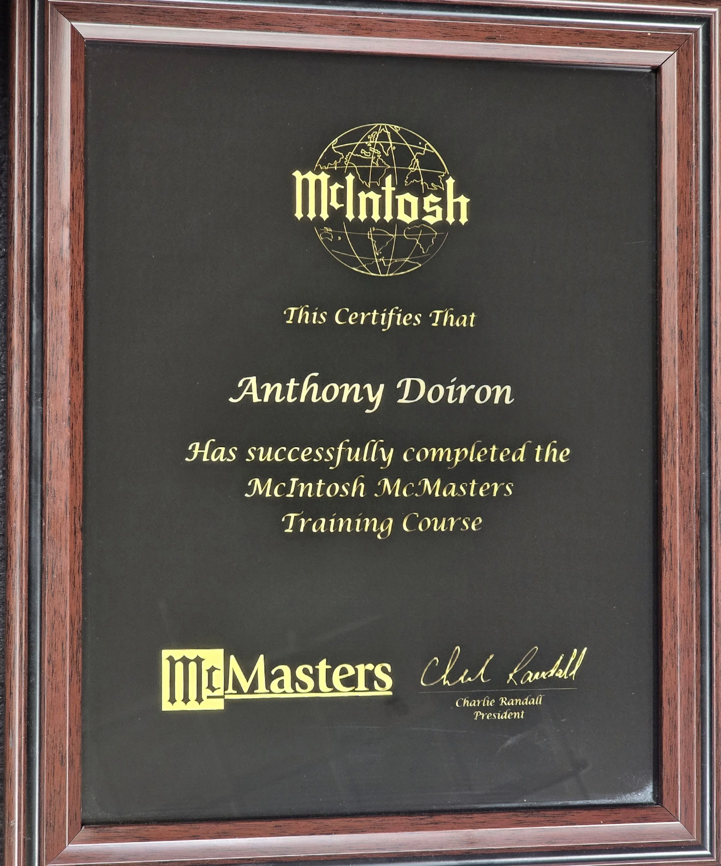A framed certificate with McIntosh logo at top, text certifying Anthony Doiron has completed the McIntosh MCMasters training course, signed by Charles Randall, President.