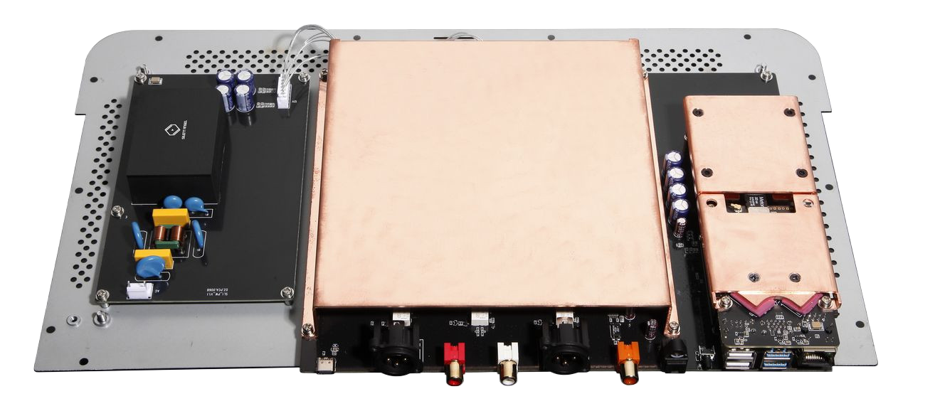 A detailed view of an electronic device's internal components including a large copper heatsink, capacitors, connectors, and circuit boards.