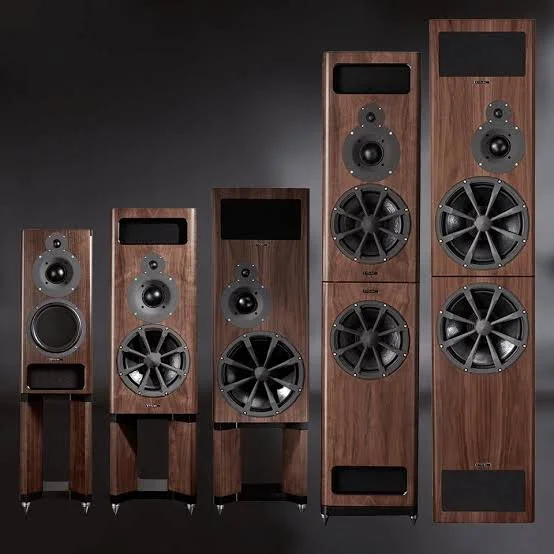 A collection of five vintage wooden loudspeakers with black speakers and stands arranged in a line against a dark background.