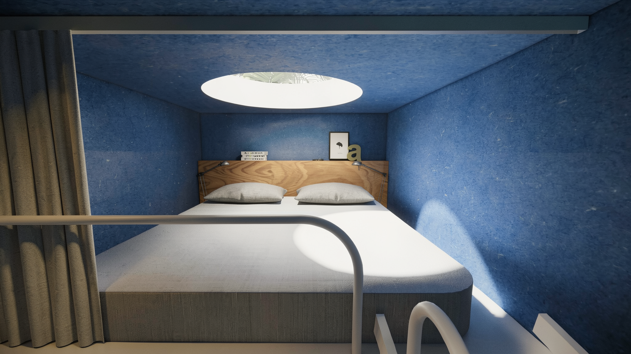 Vista desde arriba de una cama sencilla con cabecera de madera, dos almohadas grises, lámparas de lectura, cuadros decorativos y objetos sobre la cabecera en una habitación con paredes y techo azules y un domo circular de luz en el techo.
