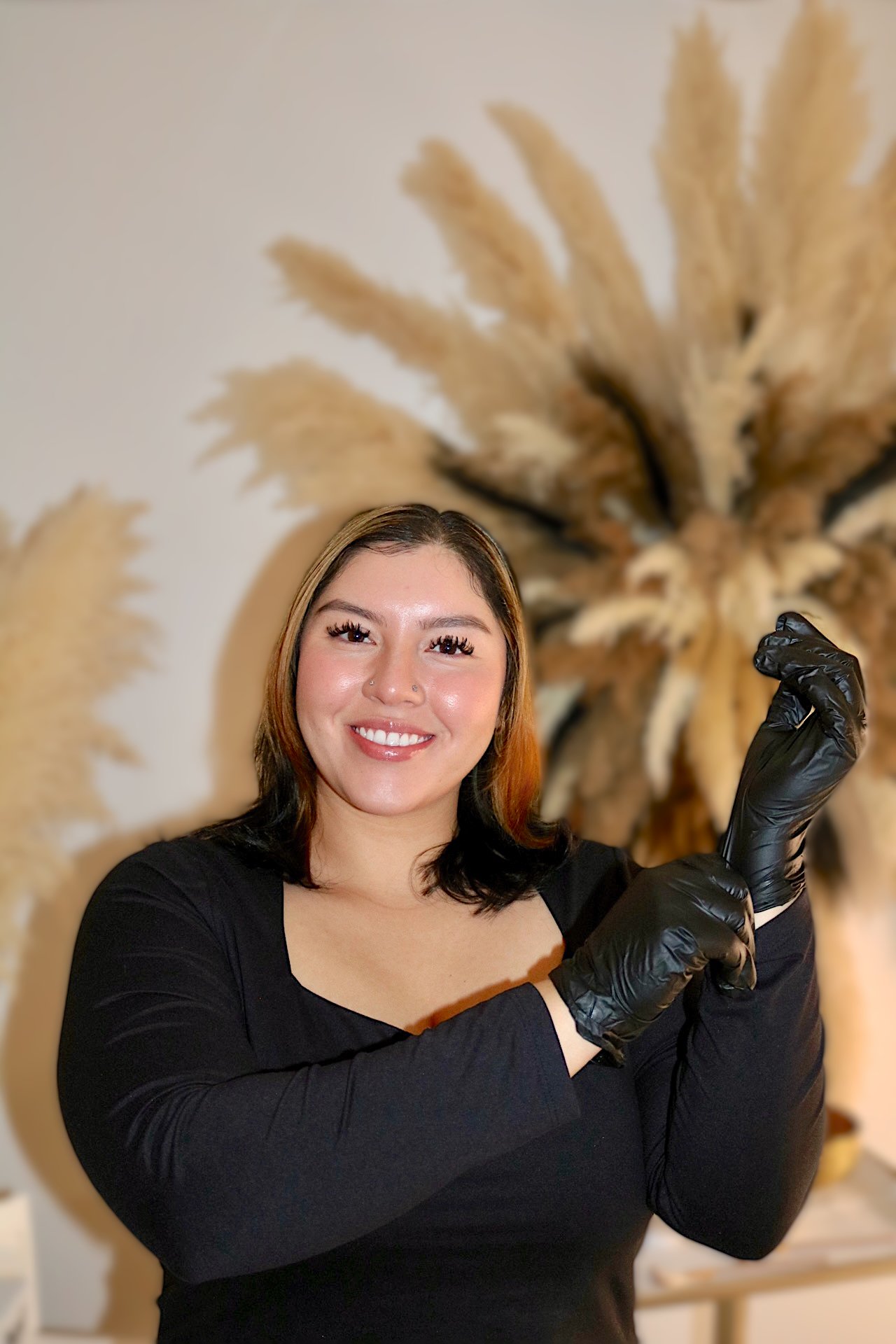 Licensed esthetician putting on gloves before a professional waxing appointment