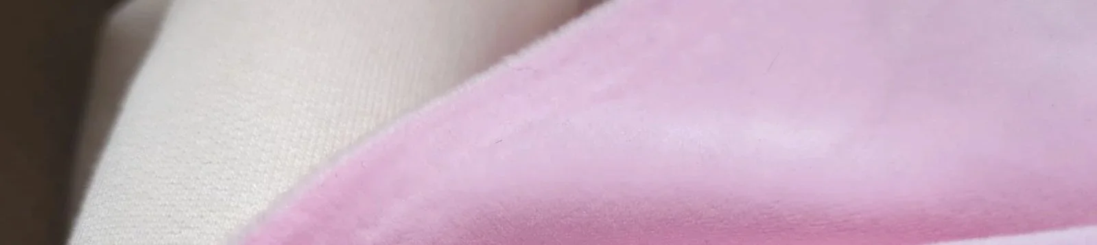 Close-up of a fabric with pink, cream, and beige colors.