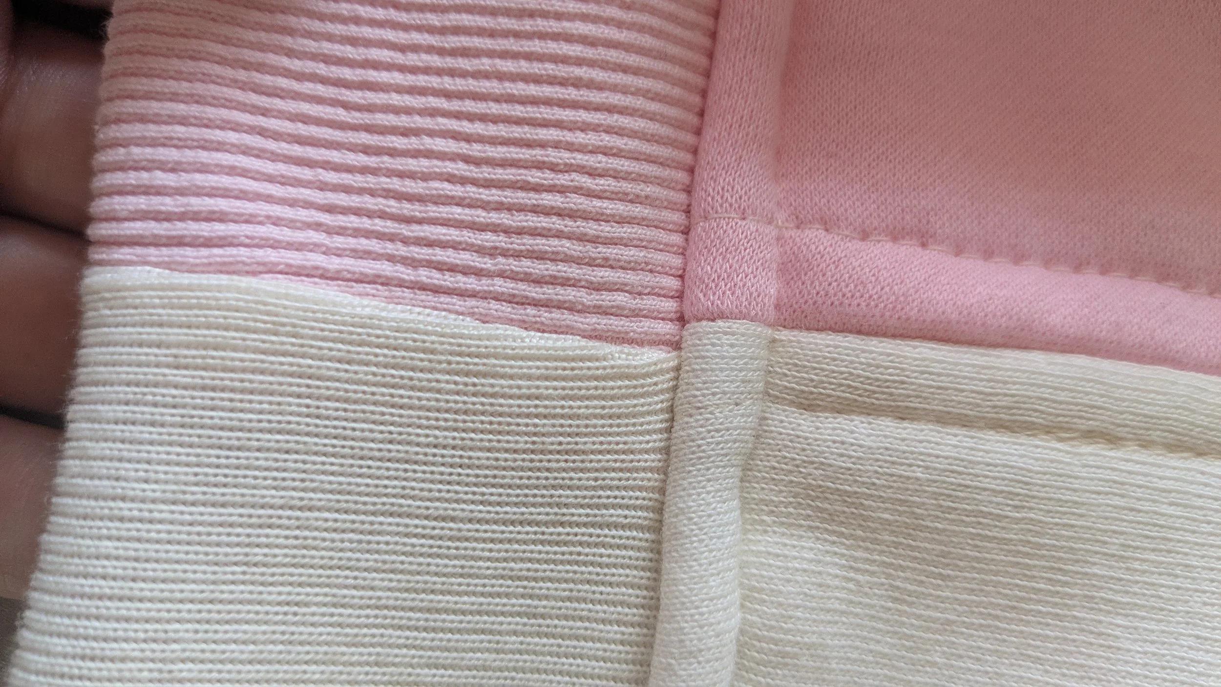 Close-up of fabric with pink and beige stripes and textured pink fabric inside.