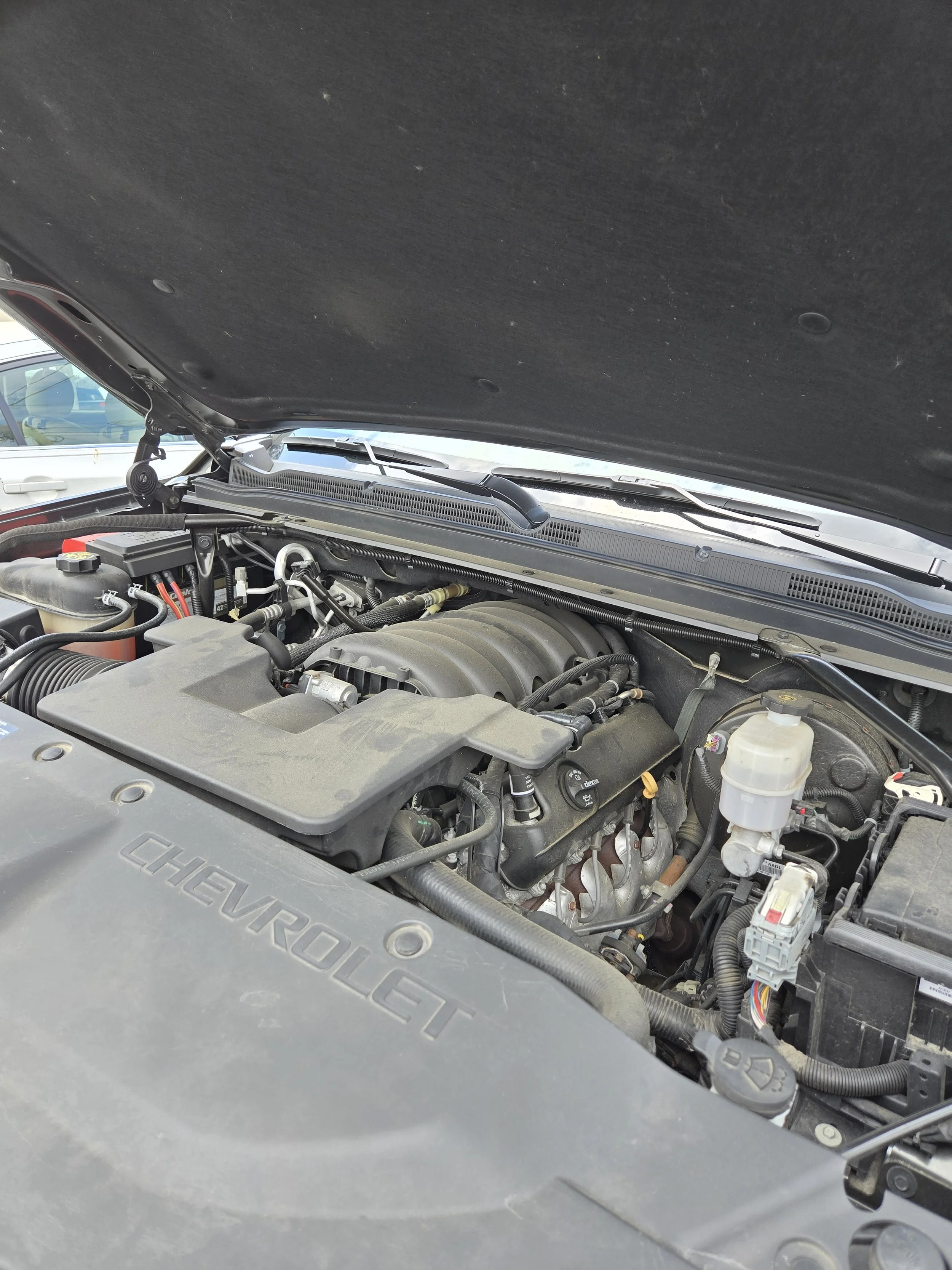 Close-up of the engine compartment of a Chevrolet vehicle with the hood open.