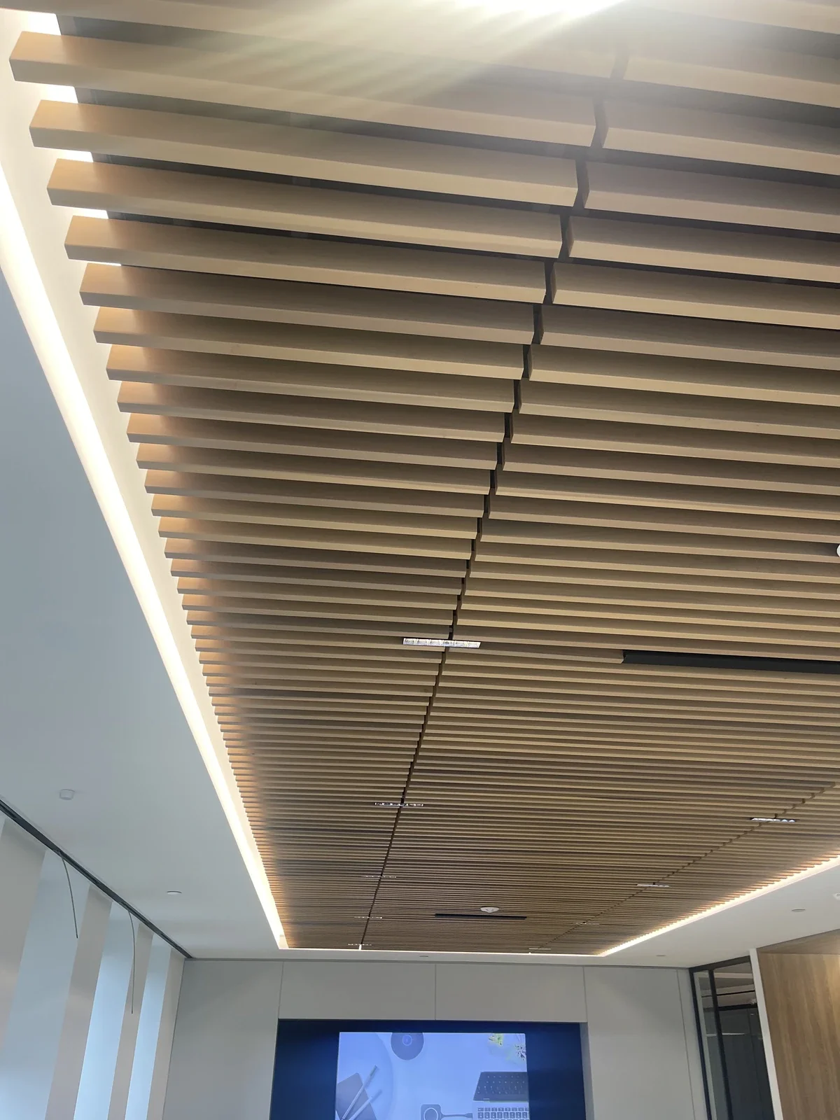 Ceiling with wooden slats in a modern interior space.