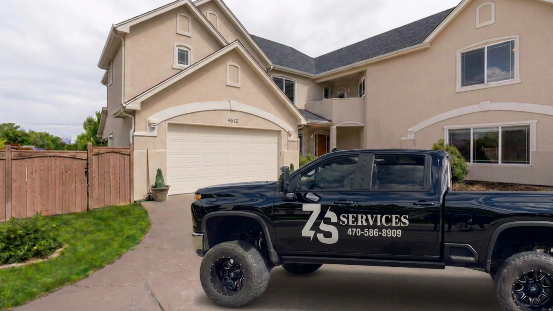 The ZS Services Truck with the phon enumber 470-586-8909 on the truck, in front of a house.