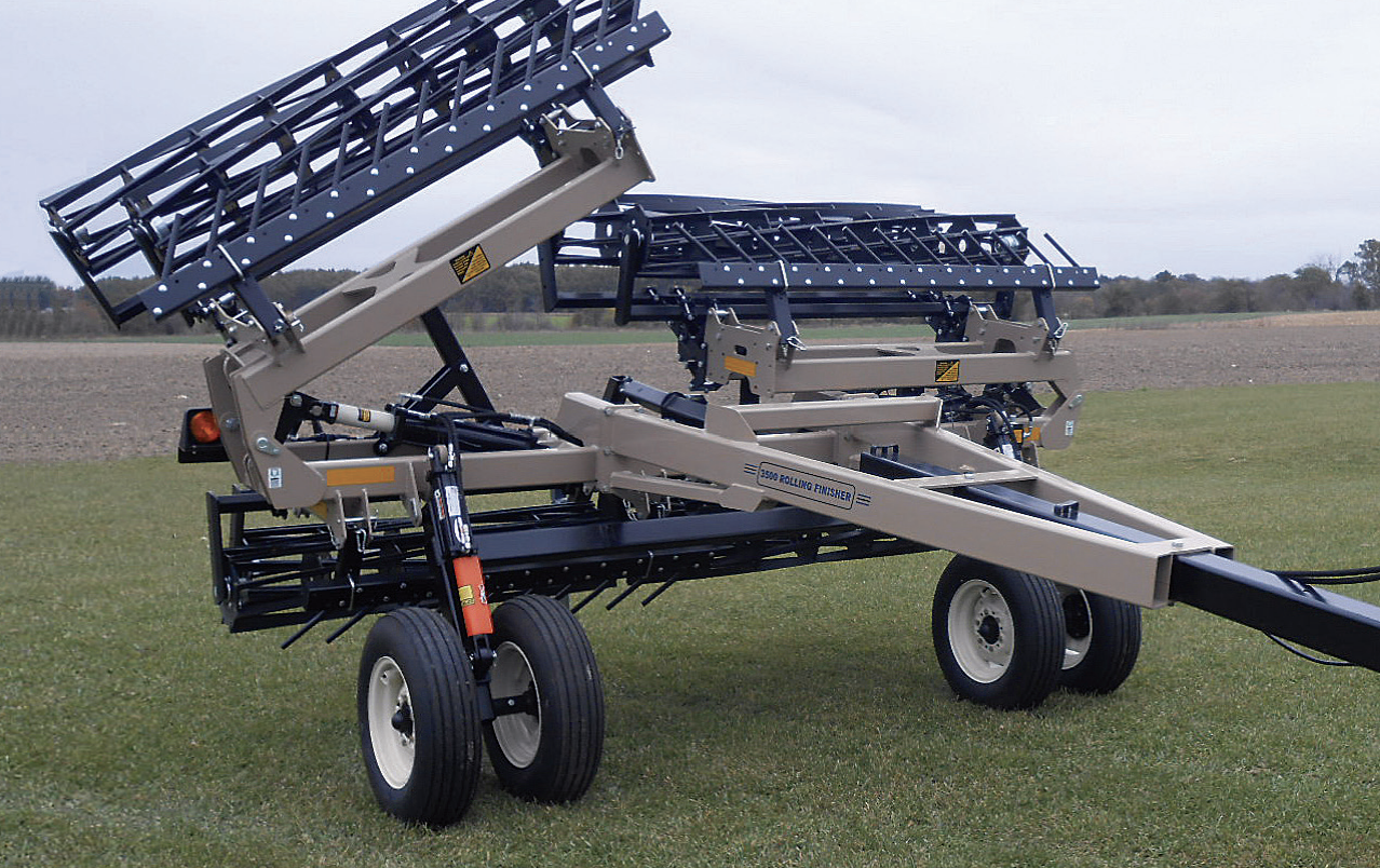Agricultural seeding equipment on a grassy field under a cloudy sky.