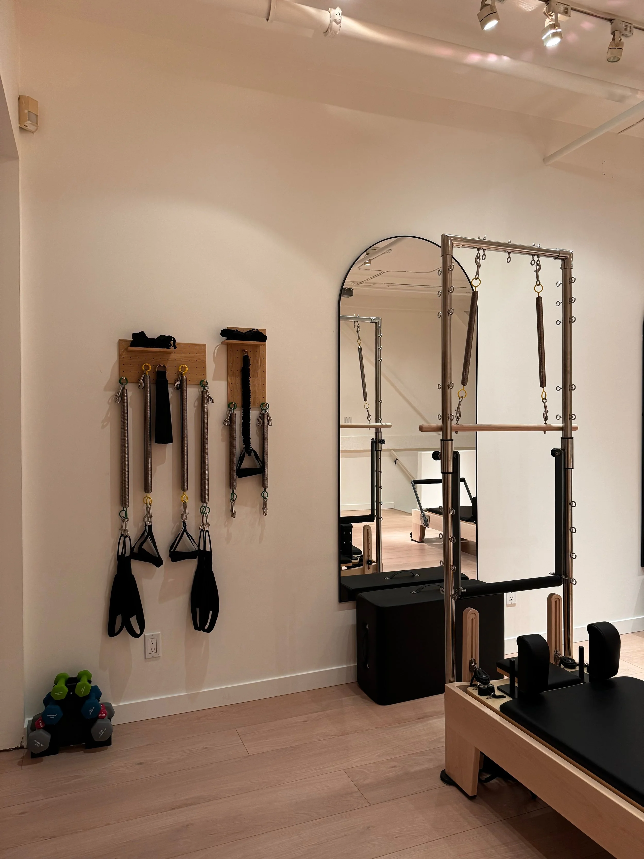 Workout room with resistance bands, dumbbells, and Pilates equipment.