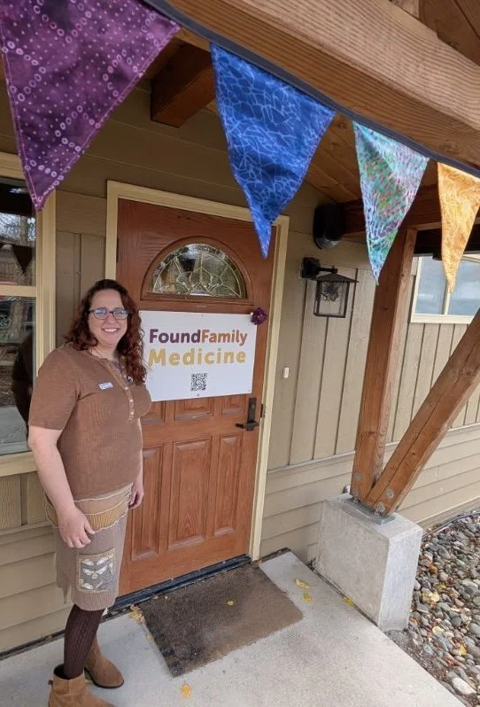 Doctor Liz Pietralczyck stands next to Found Family Medicine's front door at the clinic's grand opening event