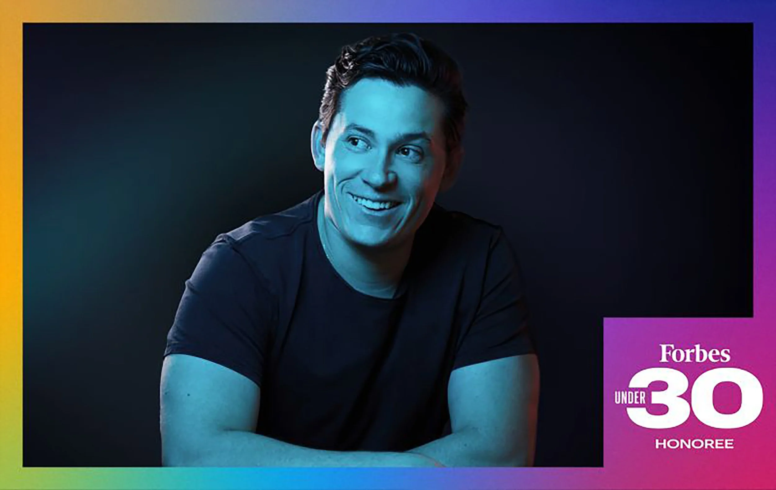 Cover of Forbes magazine, headshot in Scottsdale, featuring a smiling man with dark hair, dressed in a black t-shirt, against a dark background with a rainbow-colored border. The magazine mentions honoring persons under 30.